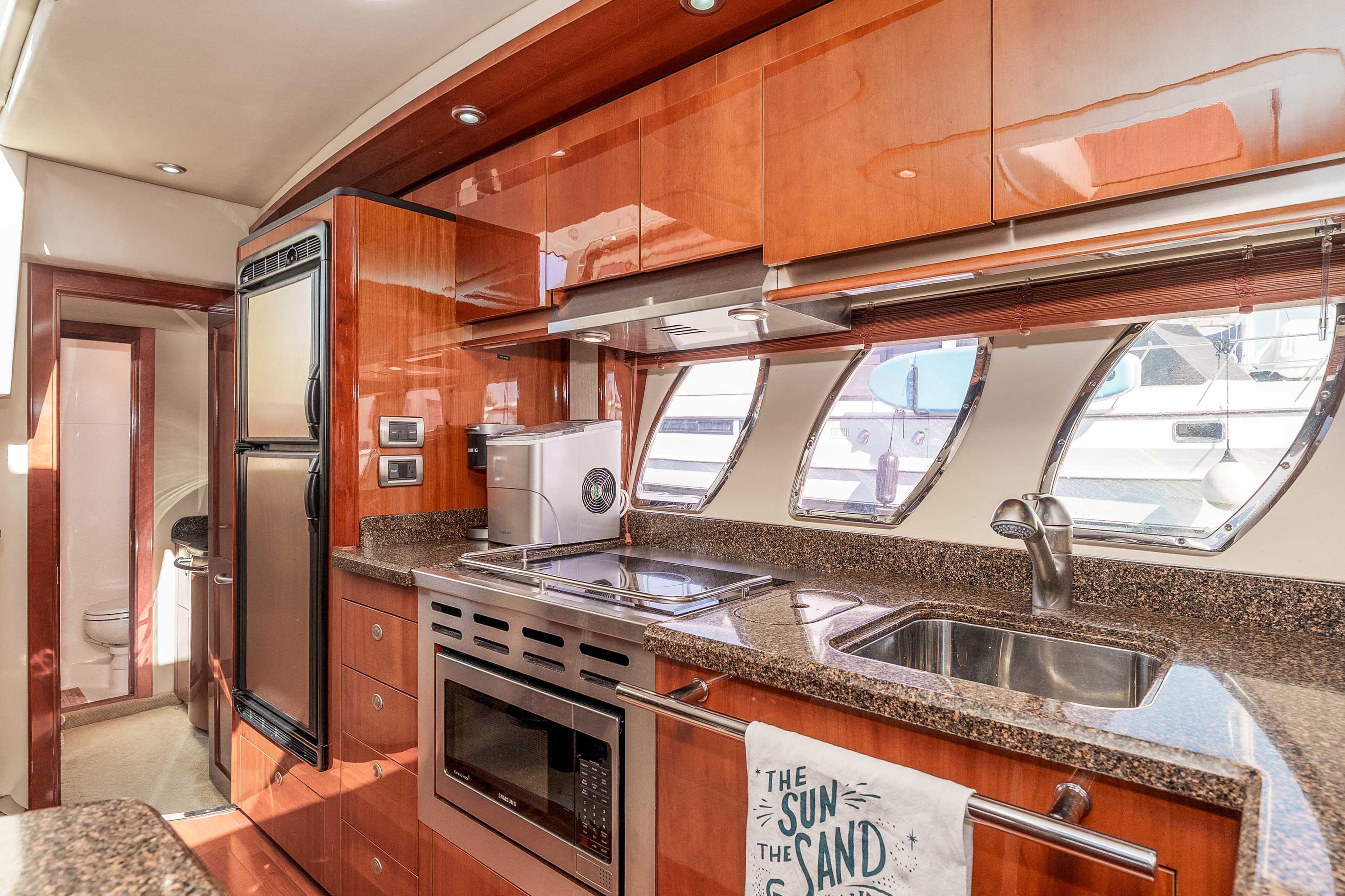 Luxurious 2007 Sea Ray 48 Sundancer yacht kitchen with modern appliances and sleek wood cabinetry.