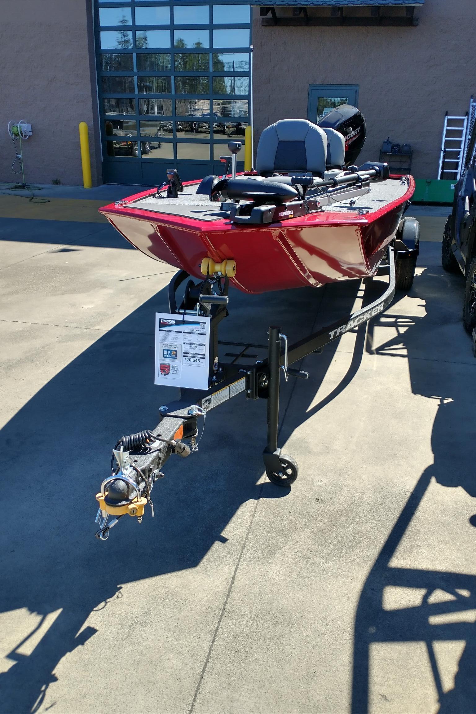 2025 Tracker Panfish 17 boat in red, parked on a trailer outdoors.