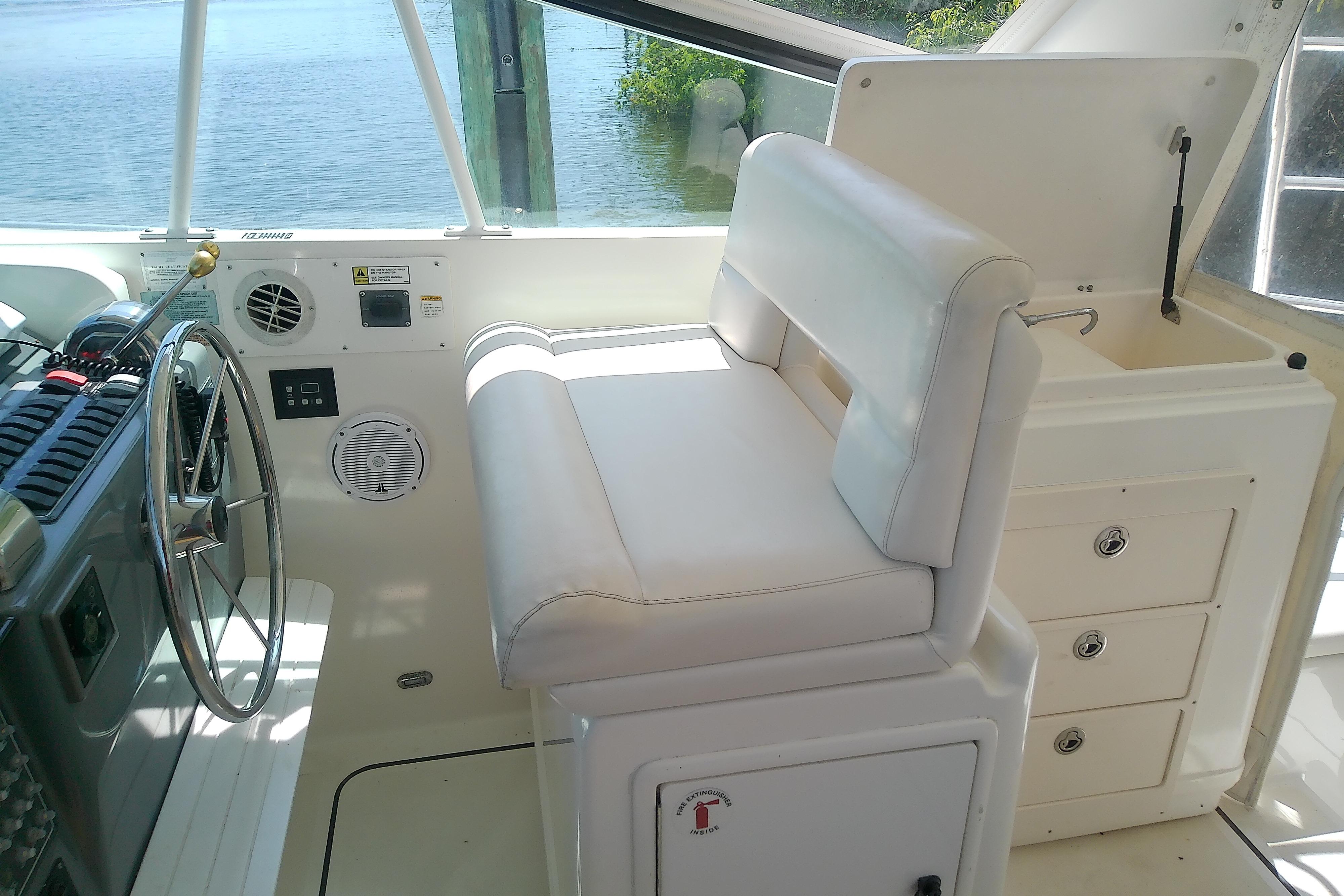 Helm of 2000 Tiara Yachts 4100 Open with white seating and steering wheel.