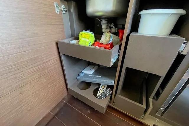 Under-sink storage in 2016 Sea Ray Sundancer 510 yacht, featuring organized kitchen essentials.