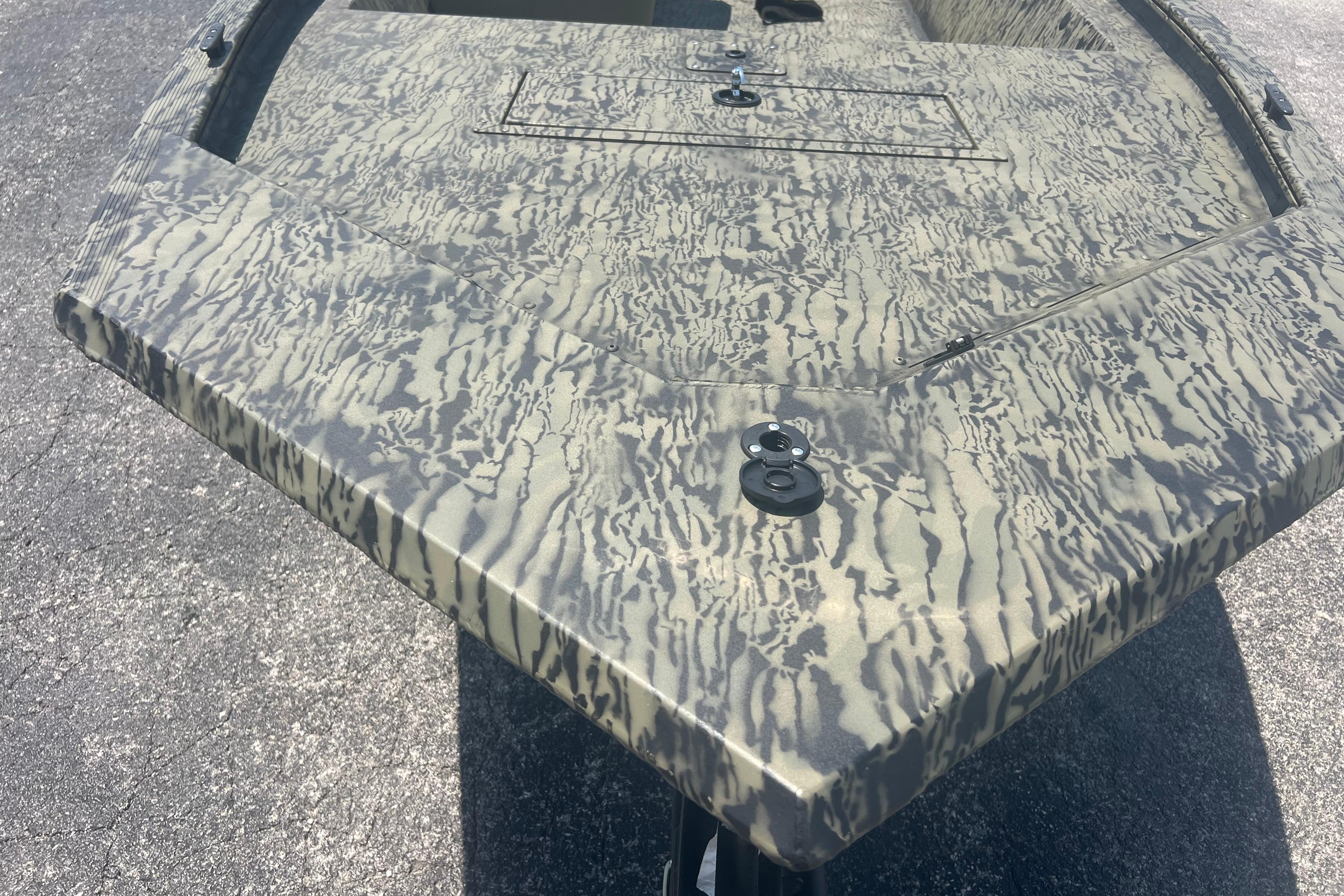 2026 Tracker Grizzly 1648 SC boat with camouflage pattern on a sunny day.