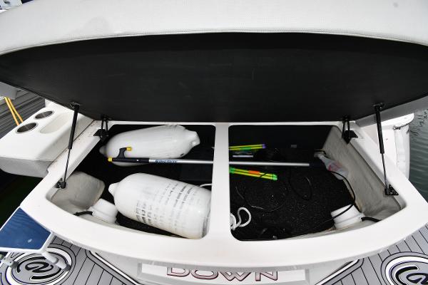 Open storage compartment on 2021 Regal 35 Sport Coupe boat with fenders and equipment.