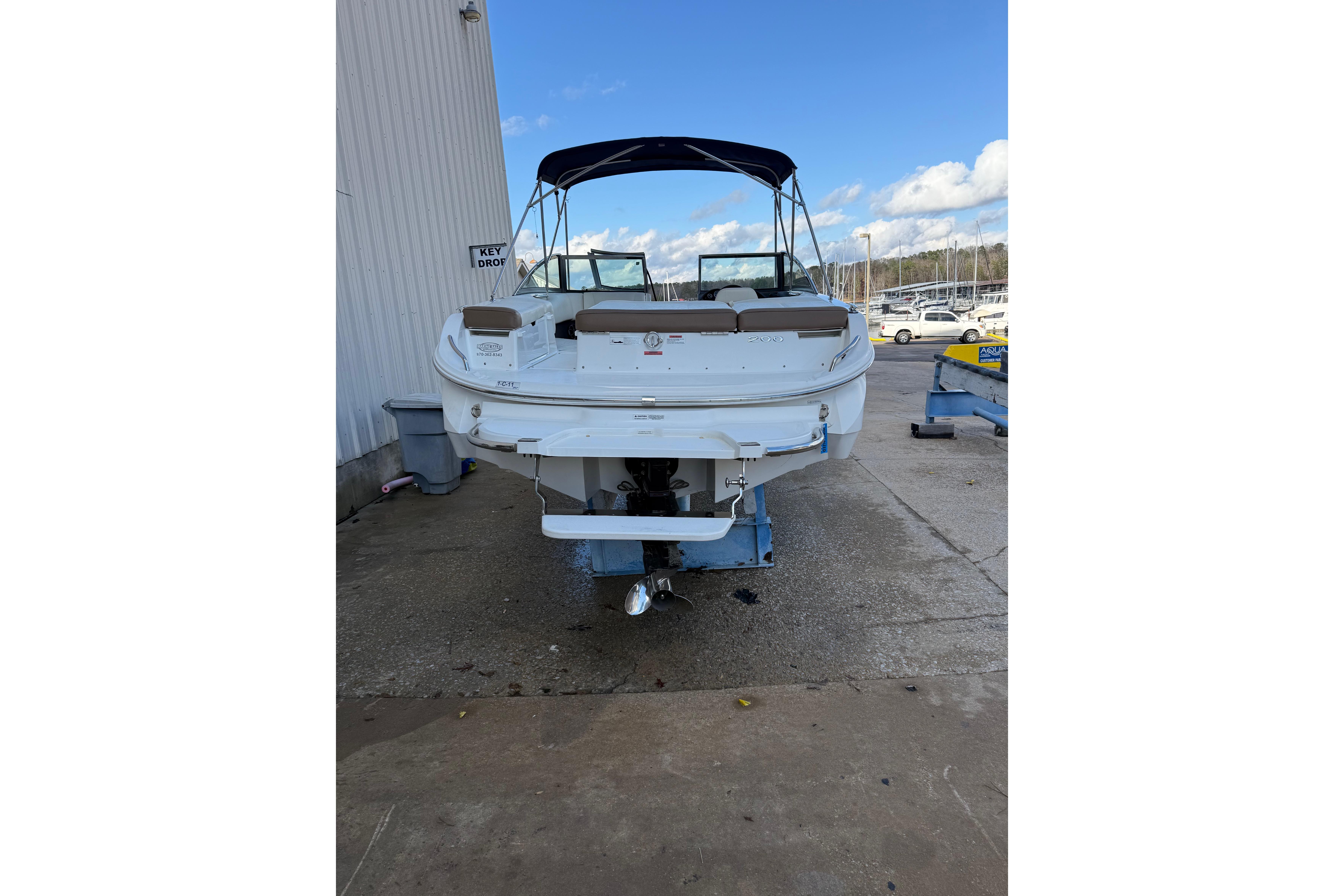 2015 Cobalt 200 boat with canopy, parked outdoors near a marina.