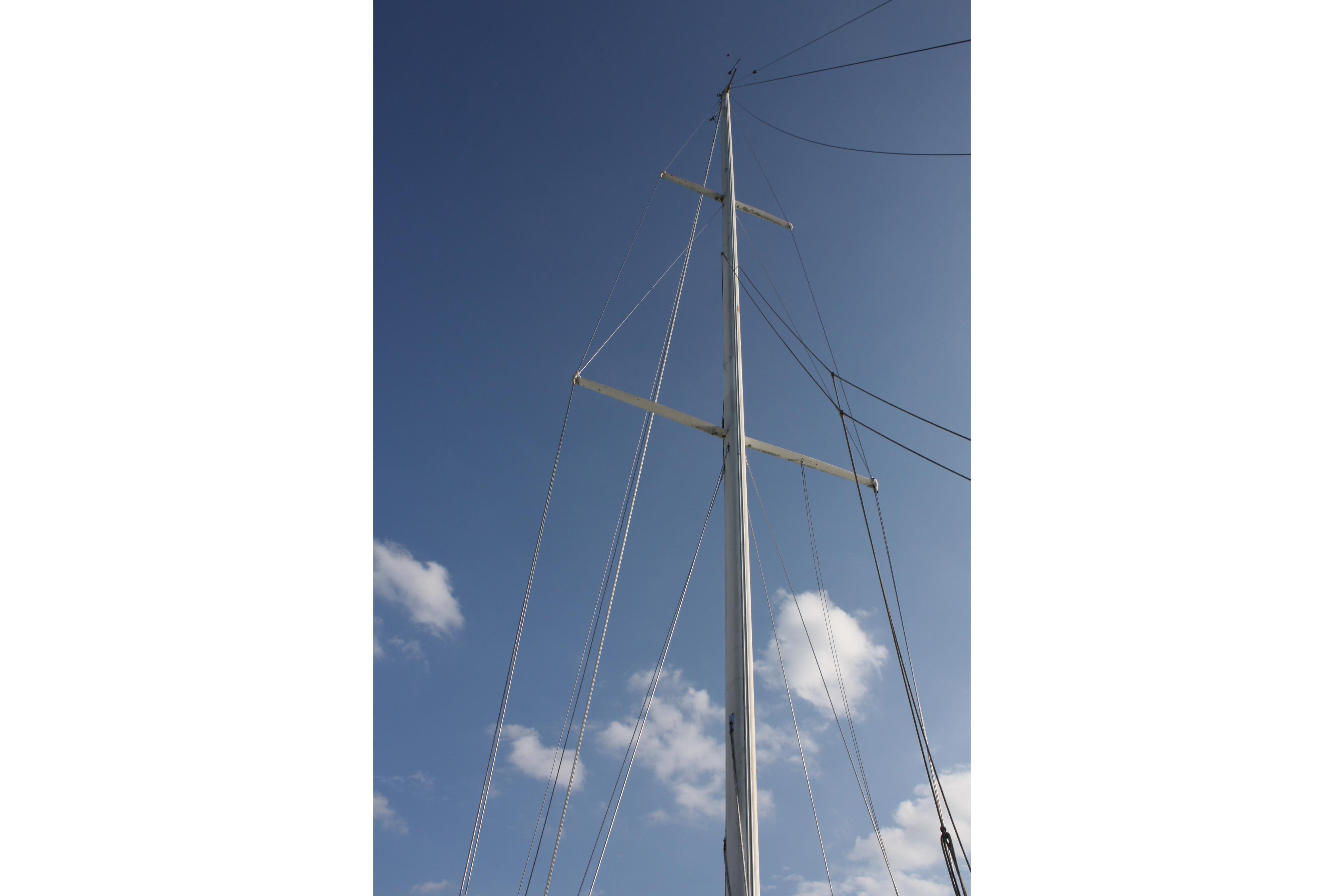 Tall mast of 1987 Ericson 38-200 sailboat against a clear blue sky.