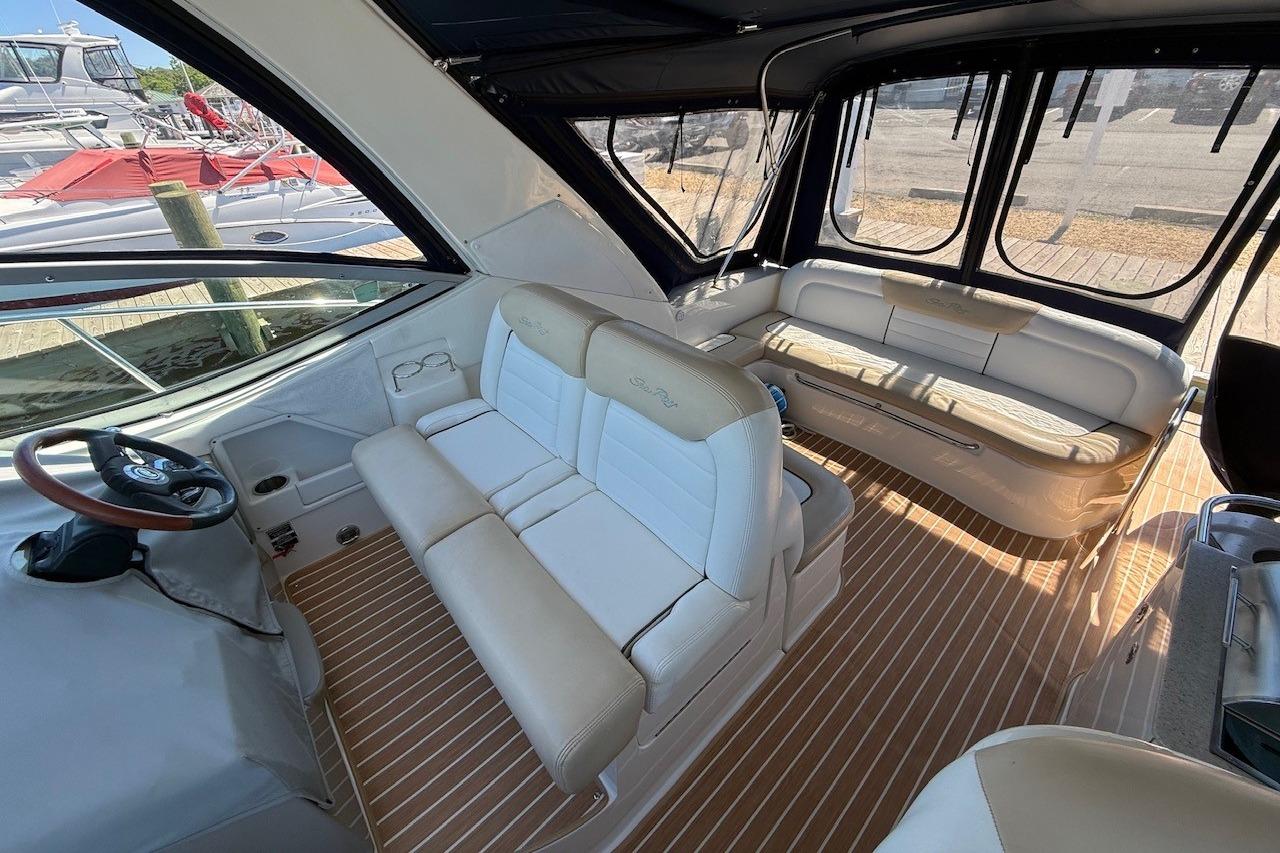 2008 Sea Ray Sundancer 330 interior with beige seating and wood-patterned flooring.