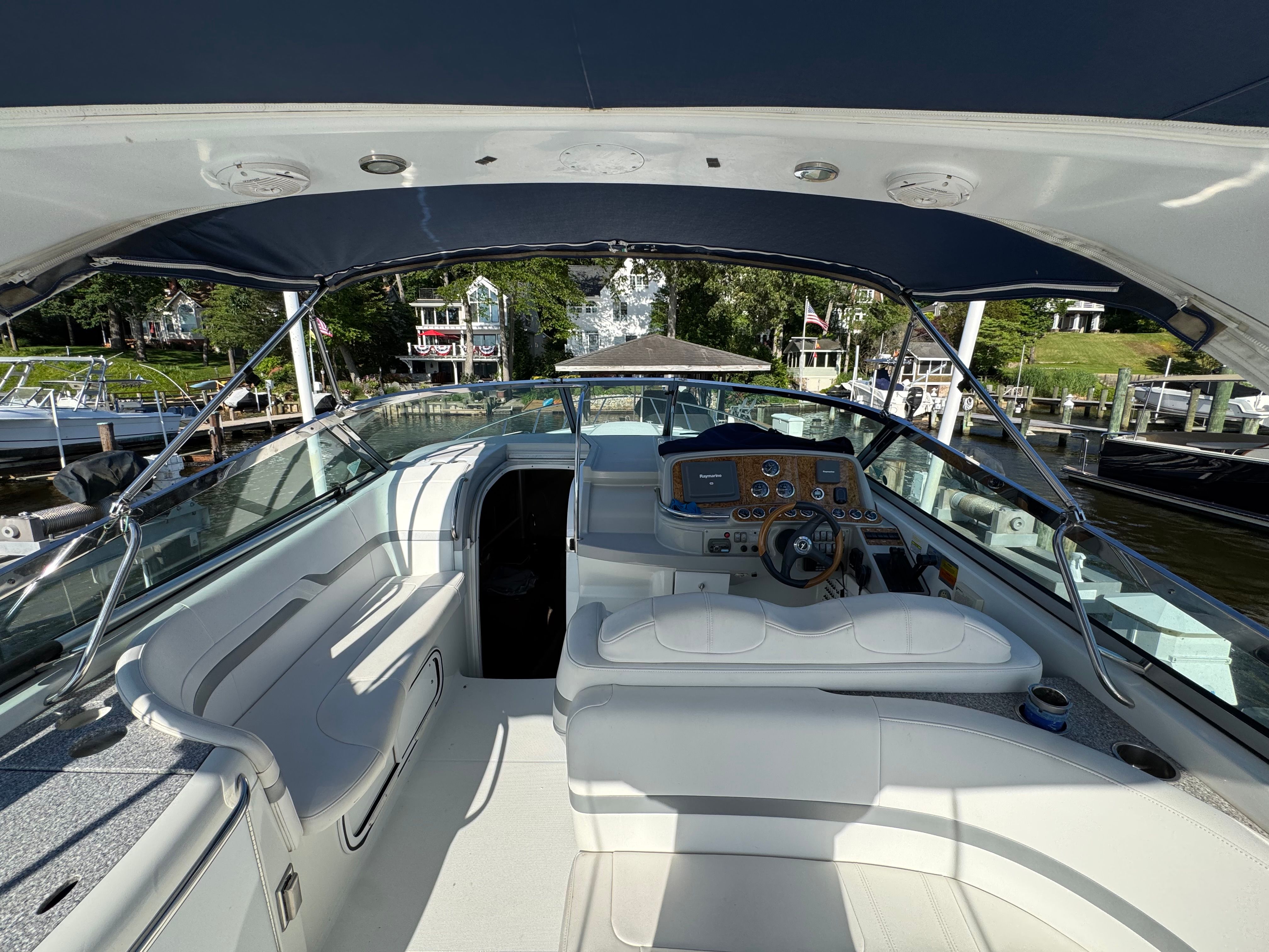 The cockpit of a luxury yacht with white seating and a sleek helm station.