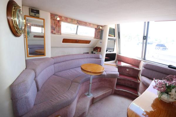 Interior of 1992 Sea Ray 350 Express Bridge with curved seating and wooden table.