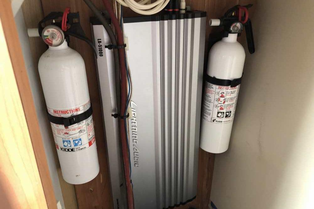 Fire extinguishers and amplifier in 1999 Regal Commodore 2760 boat compartment.