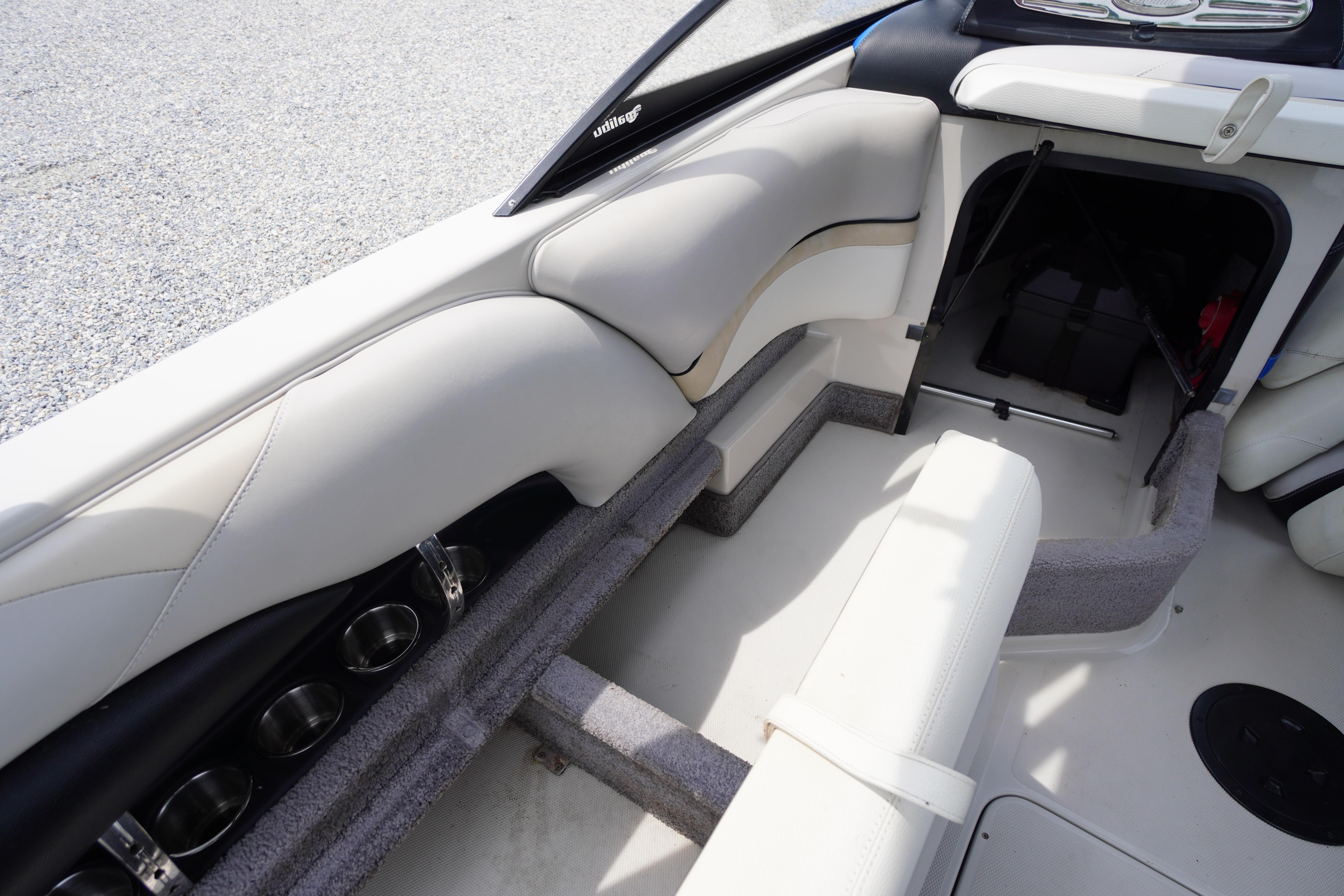 Interior of 2011 Malibu Wakesetter 21 VLX boat with white seating and storage compartment.