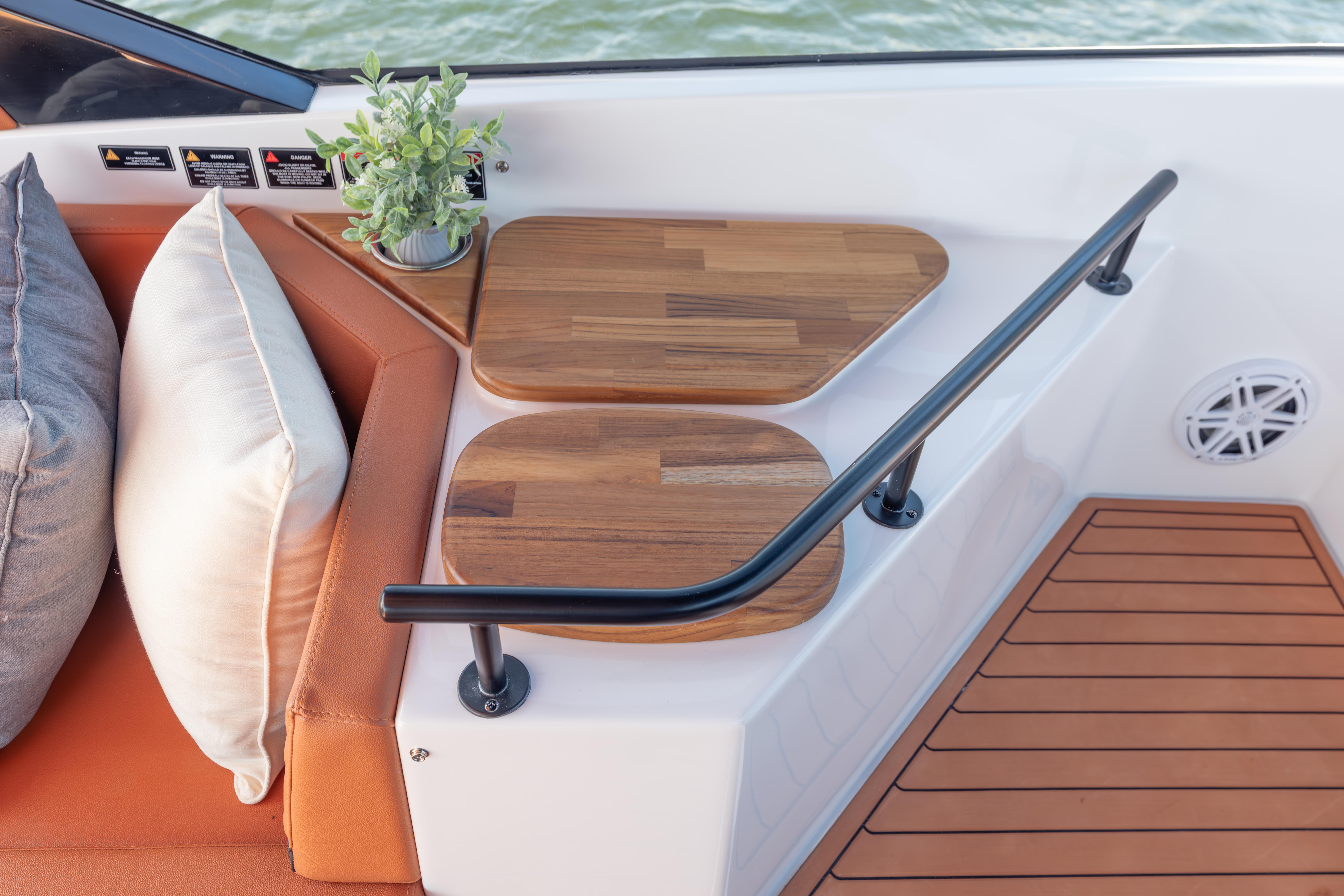 Luxurious Hanover 387 boat interior with wooden tables, cushions, and potted plant, 2026 model.