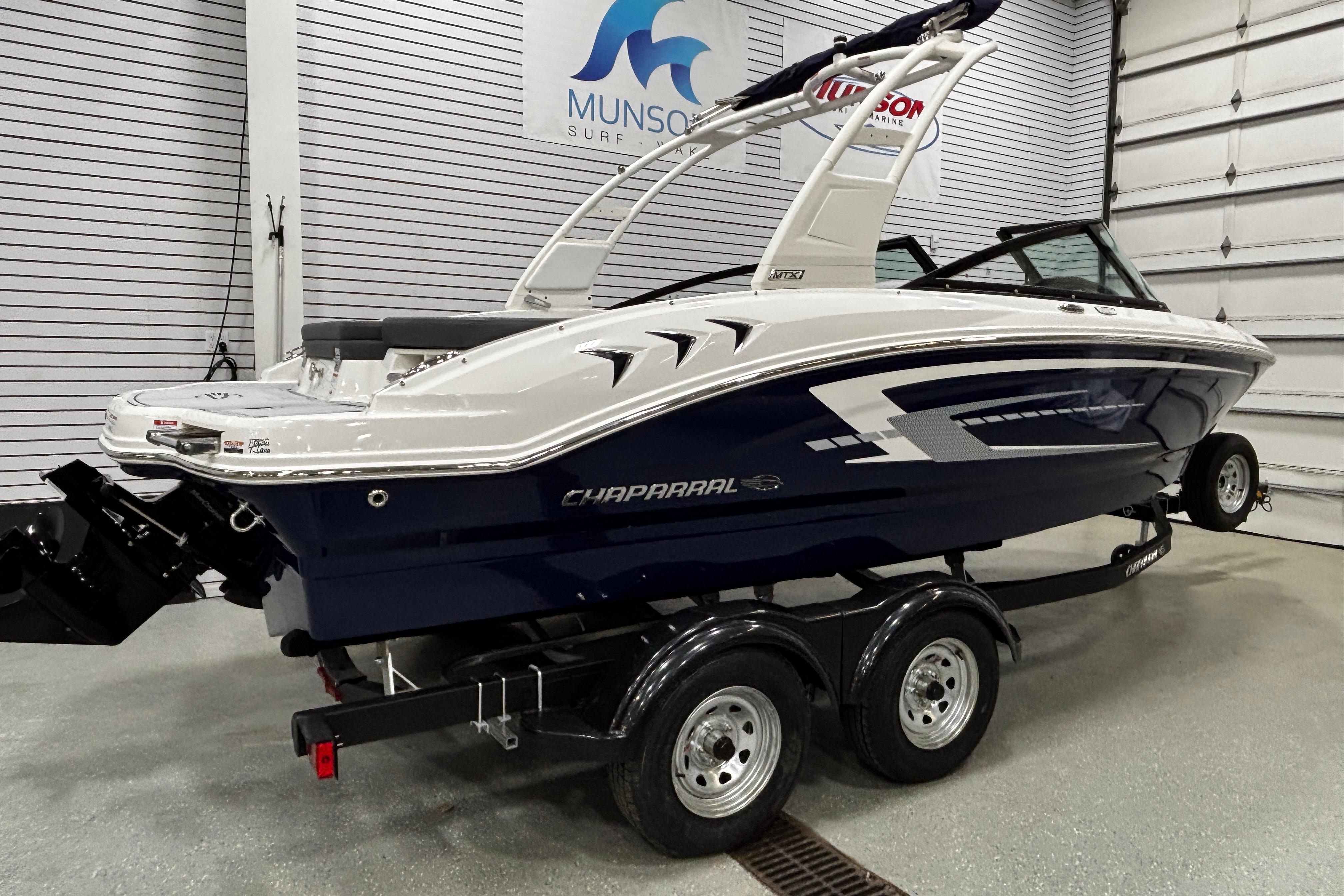 2026 Chaparral 21 SSi boat on trailer in showroom, side view.