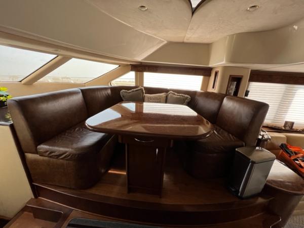 Luxurious 2009 Ovation 52 yacht interior with leather seating and dining table.