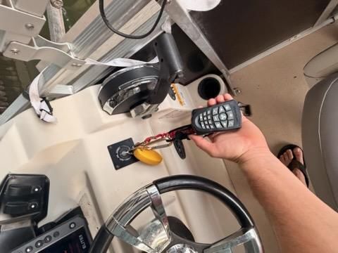 Close-up of a boat's helm with controls and a radio handset.