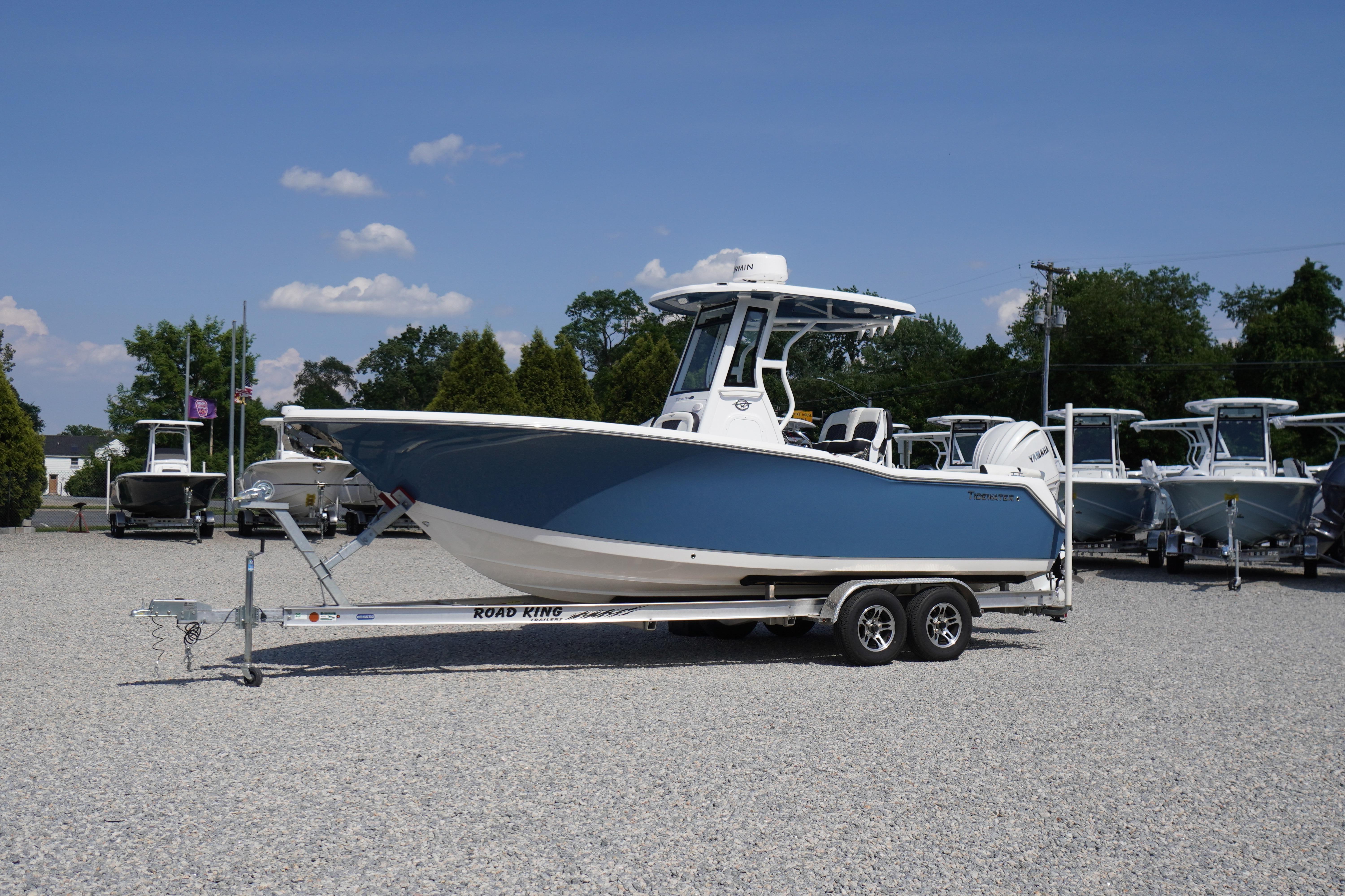 2025 Tidewater 232 SS boat on trailer, parked outdoors under clear blue sky.