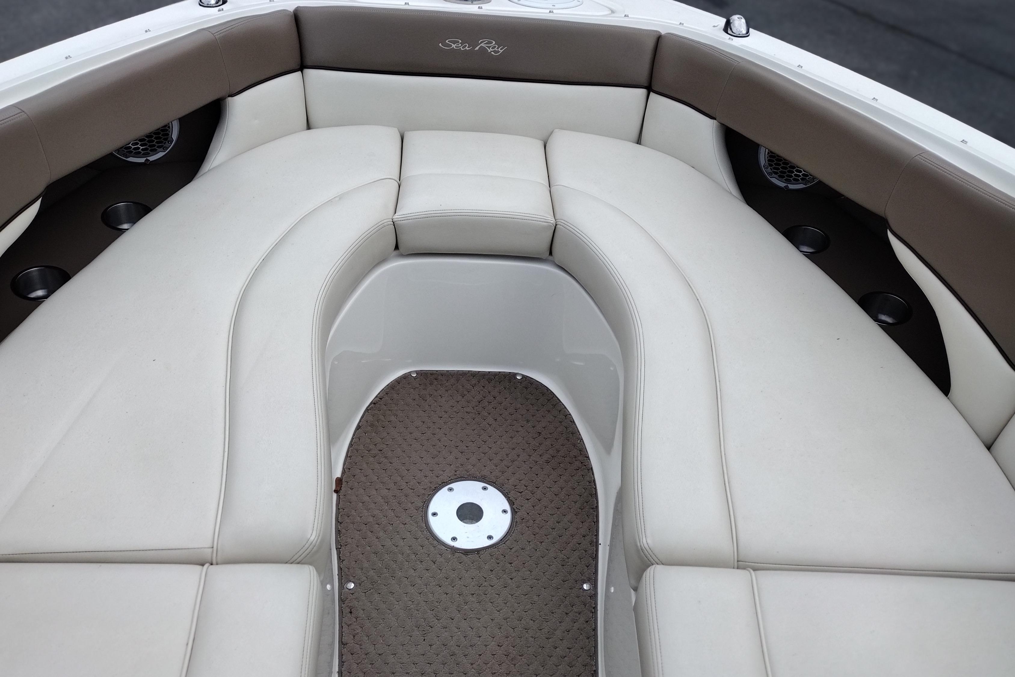 Interior seating of a 2013 Sea Ray 300 SLX boat, featuring beige upholstery and cup holders.