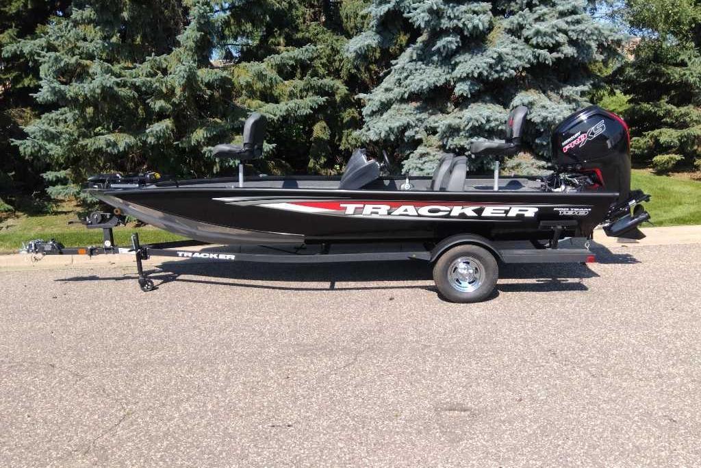 2026 Tracker Pro Team 190 boat on trailer, parked outdoors with trees in background.
