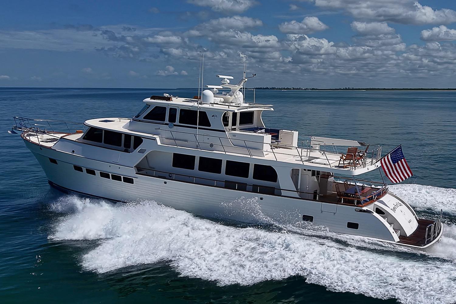 2014 Marlow 80 Explorer yacht cruising on open water under a partly cloudy sky.