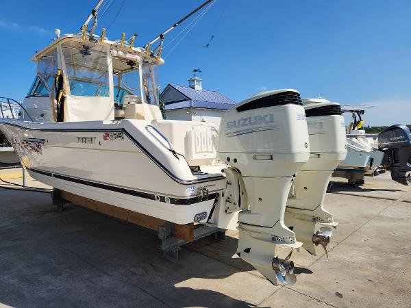 2005 Pursuit 3070 Offshore Center Console boat with twin Suzuki outboard engines.