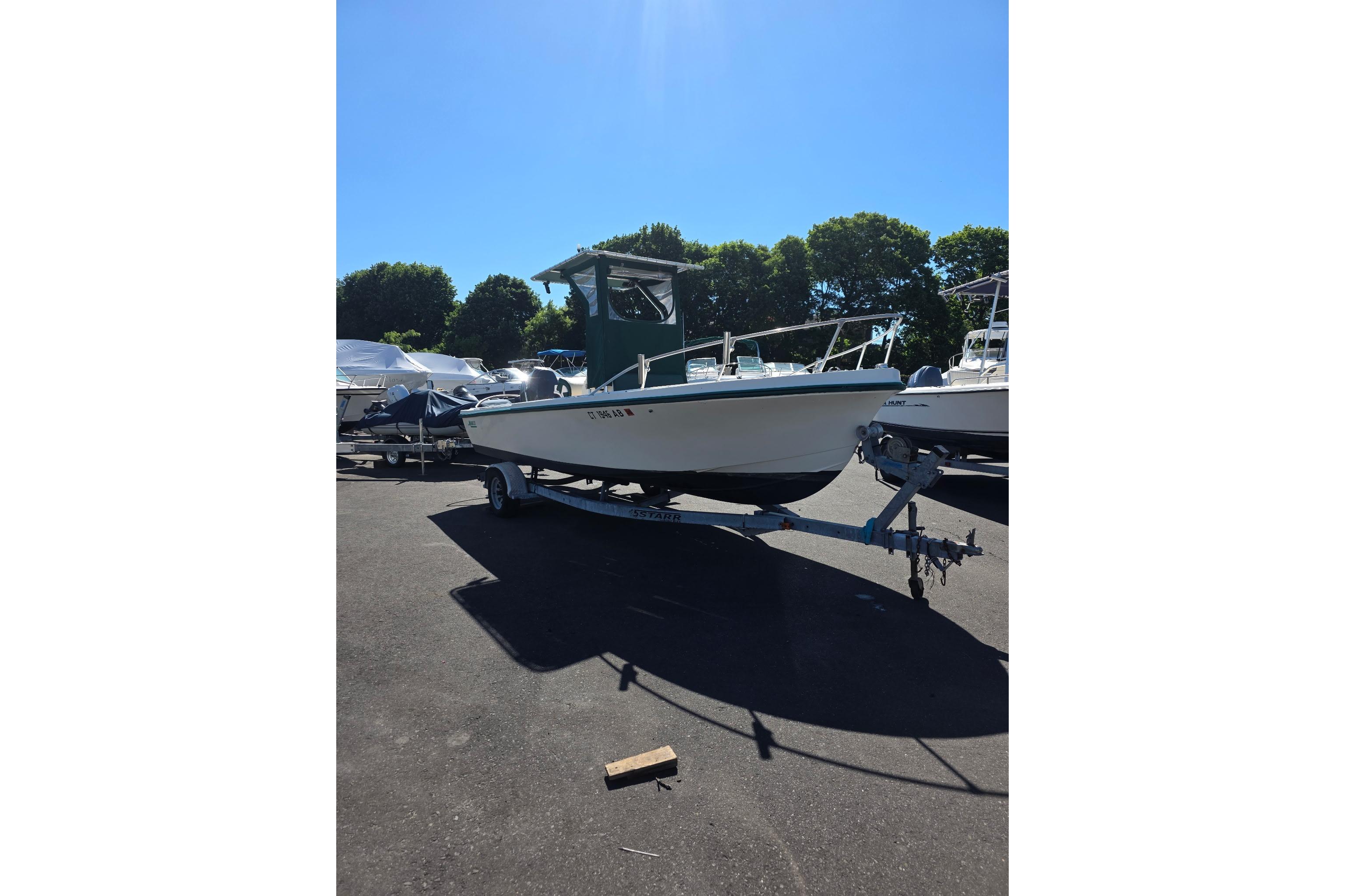 1982 Mako 20 Center Console boat on trailer under clear blue sky.