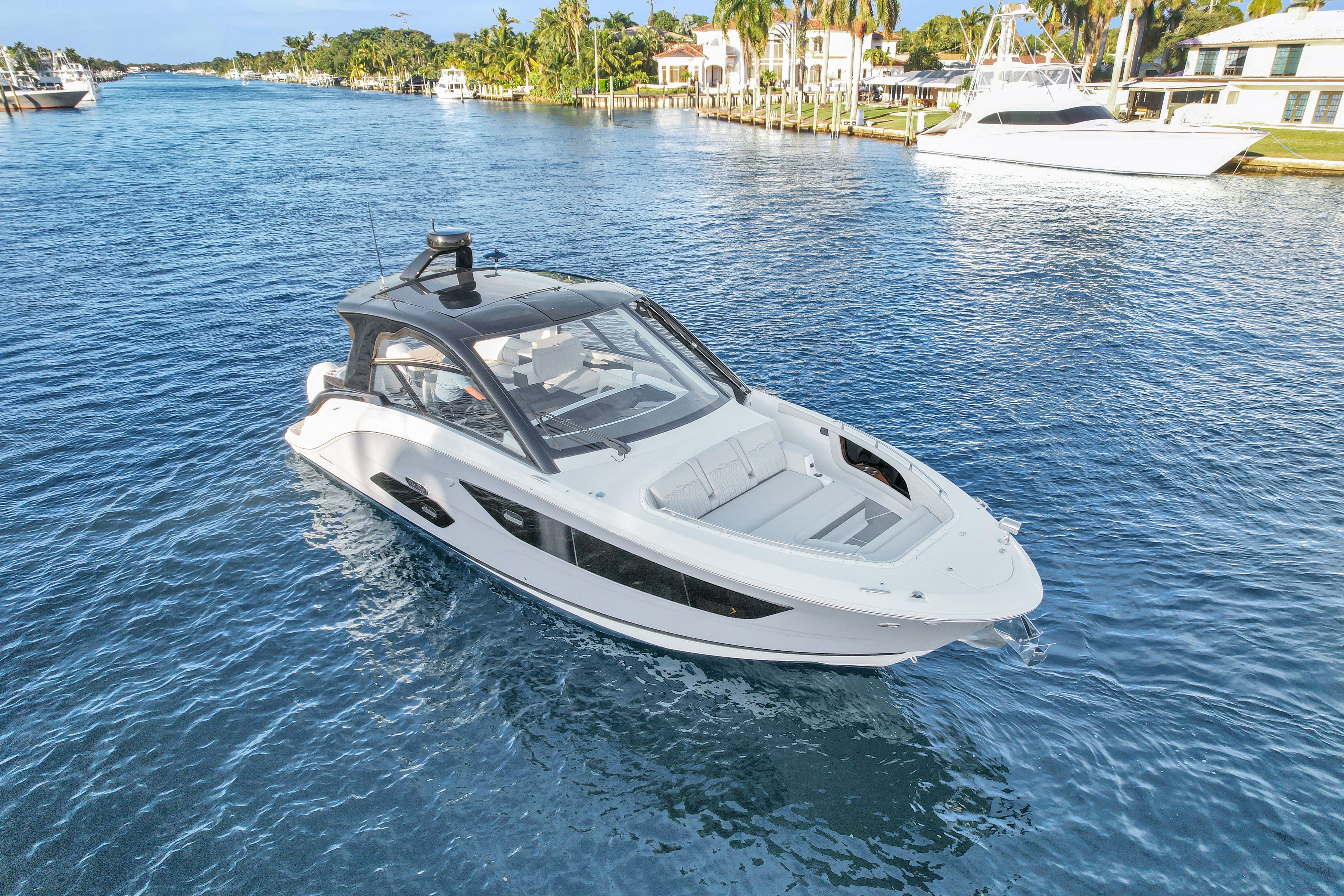 2023 Sea Ray Sundancer 370 on calm water near coastal homes.
