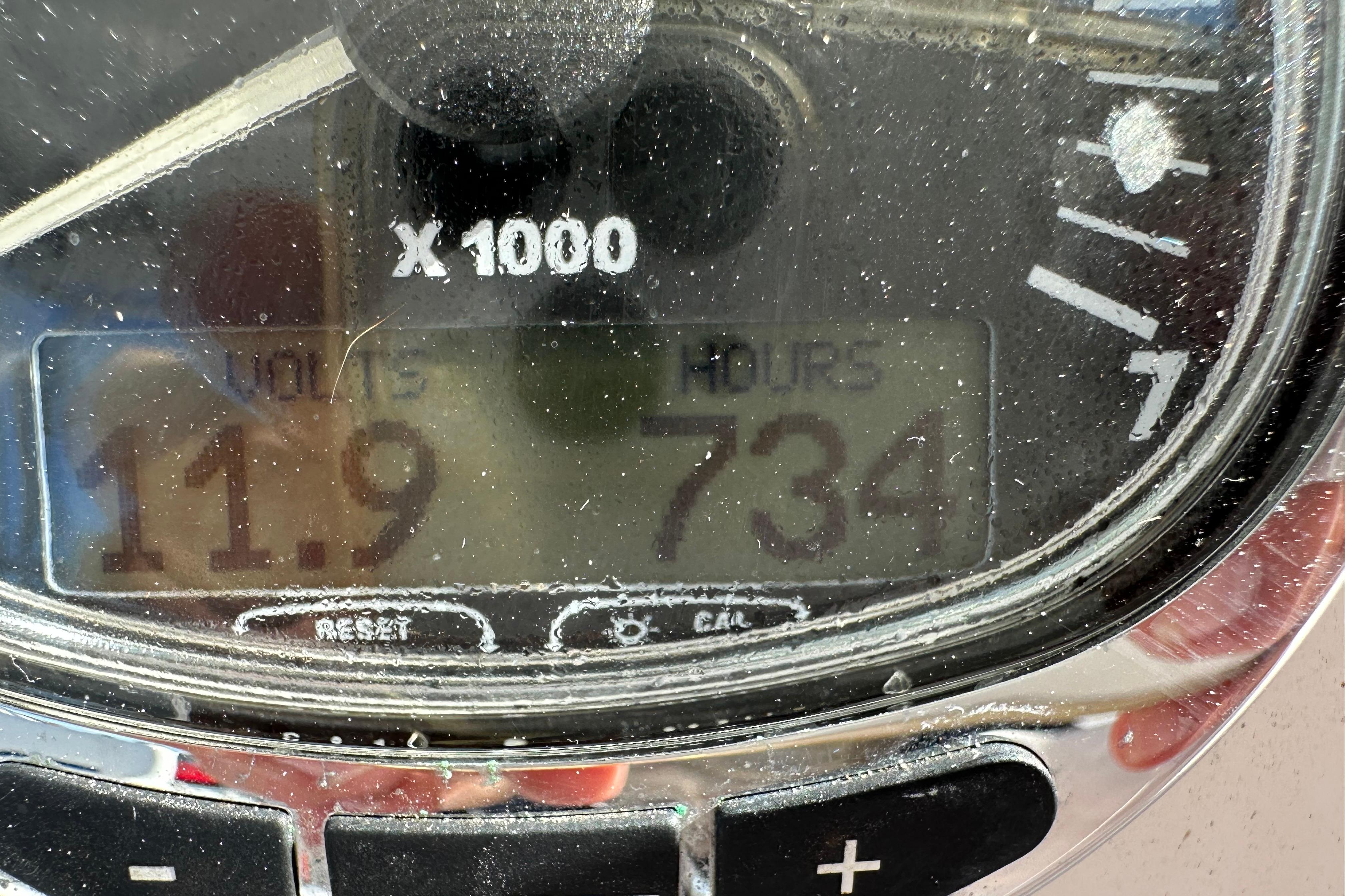 Close-up of a 2006 Pro-Line 32 Express boat gauge displaying 11.9 volts and 734 hours.