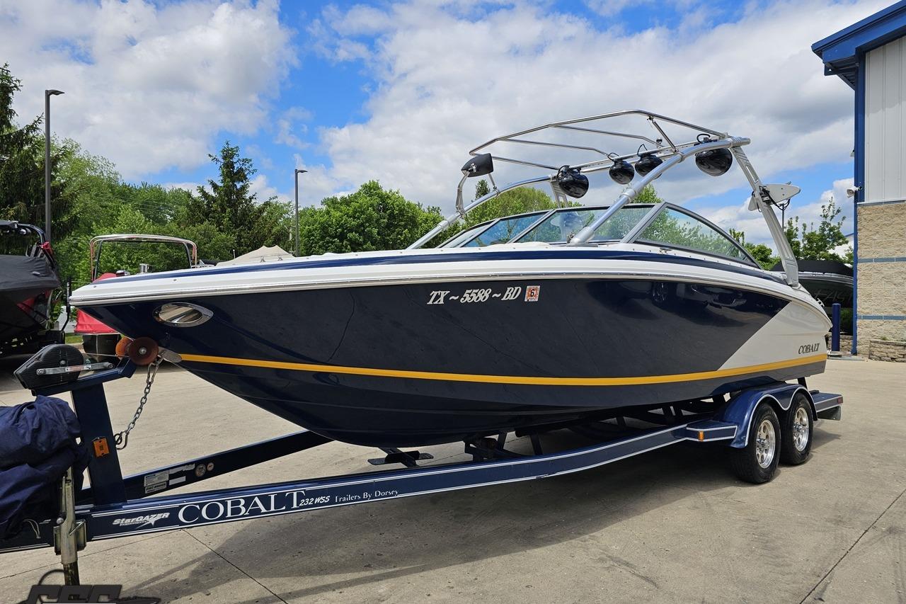 2010 Cobalt 232 WSS boat on trailer, parked outdoors under a partly cloudy sky.