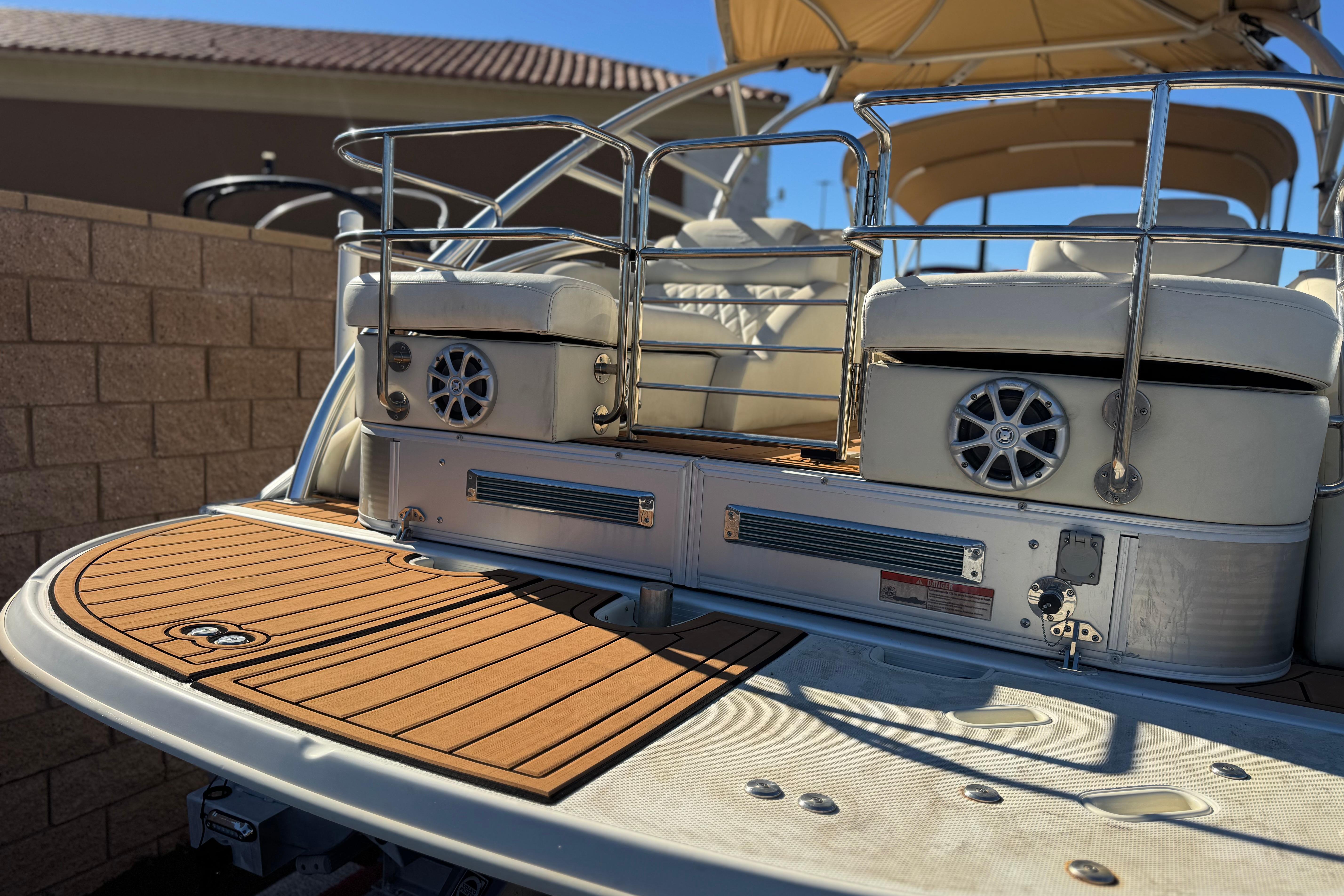 2013 Bennington 2575QCW I/O boat with teak deck and cushioned seating.
