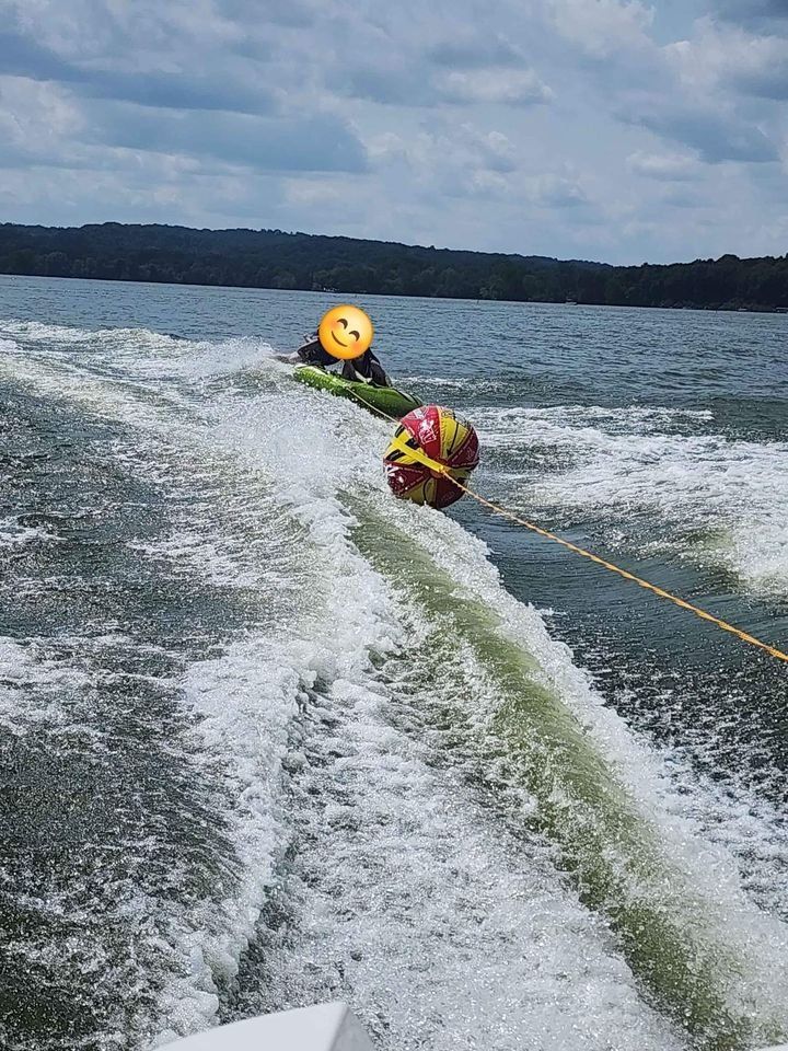 Person tubing behind Campion Explorer 542 Sport Cabin boat, 2012.