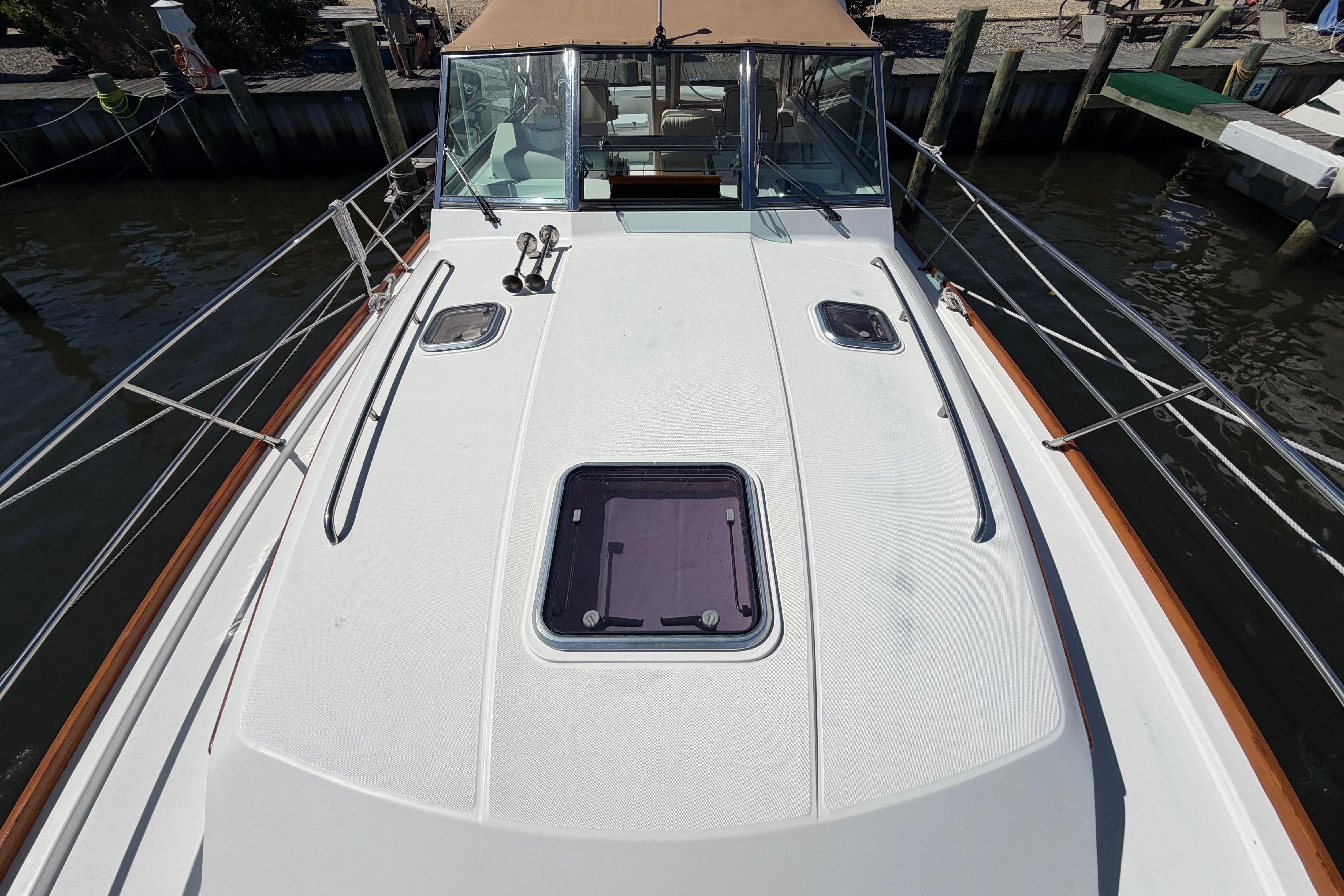2000 Sabreline 36 Express boat deck with hatch and railing, docked by the water.