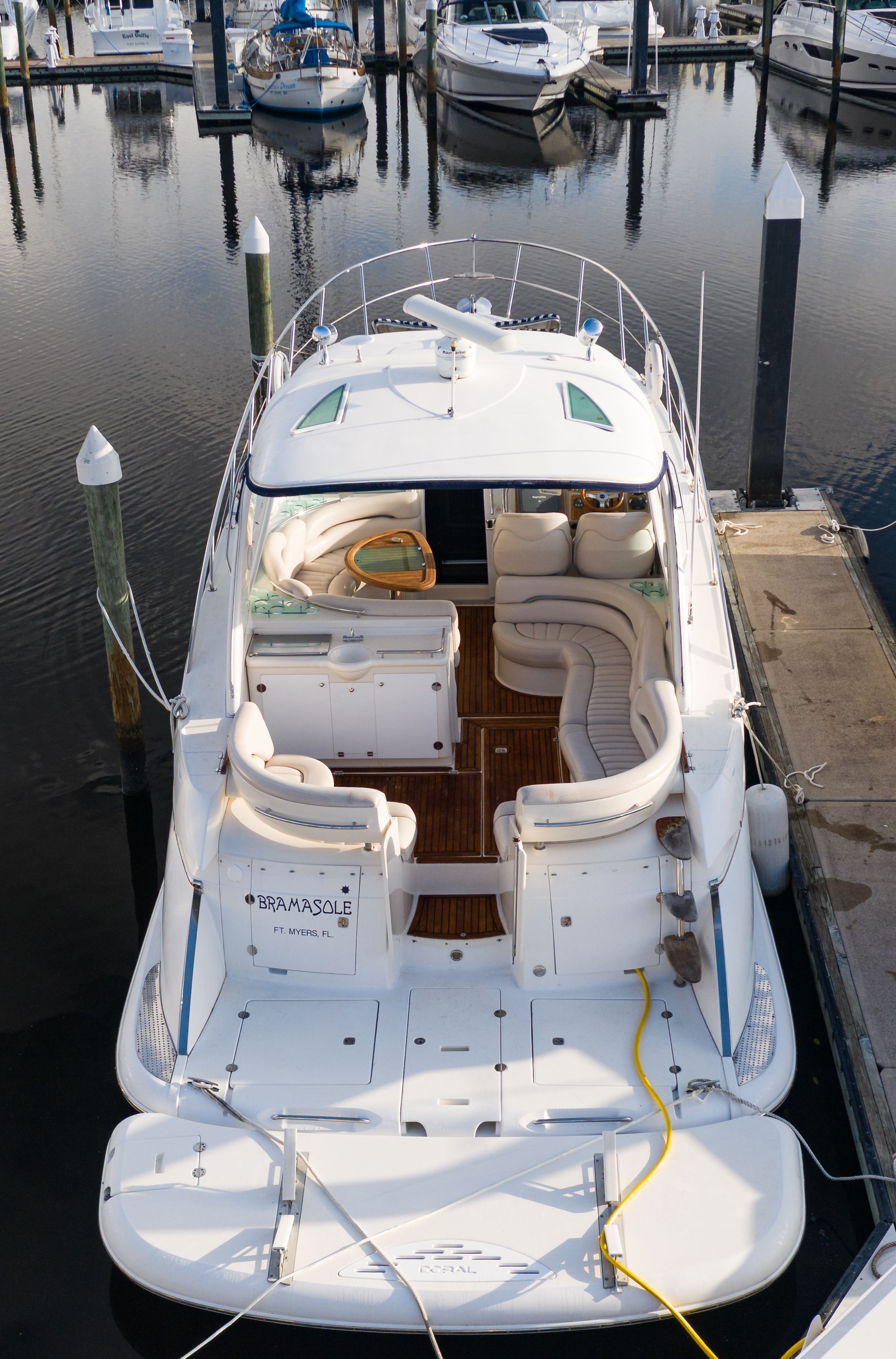 A luxurious 2004 Doral Alegria yacht docked, featuring a spacious deck and elegant seating.