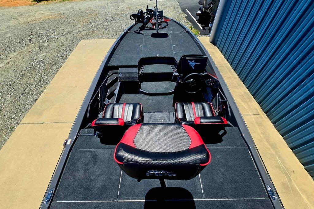 2026 Skeeter ZXE20 boat interior with black and red seating, parked near a blue building.