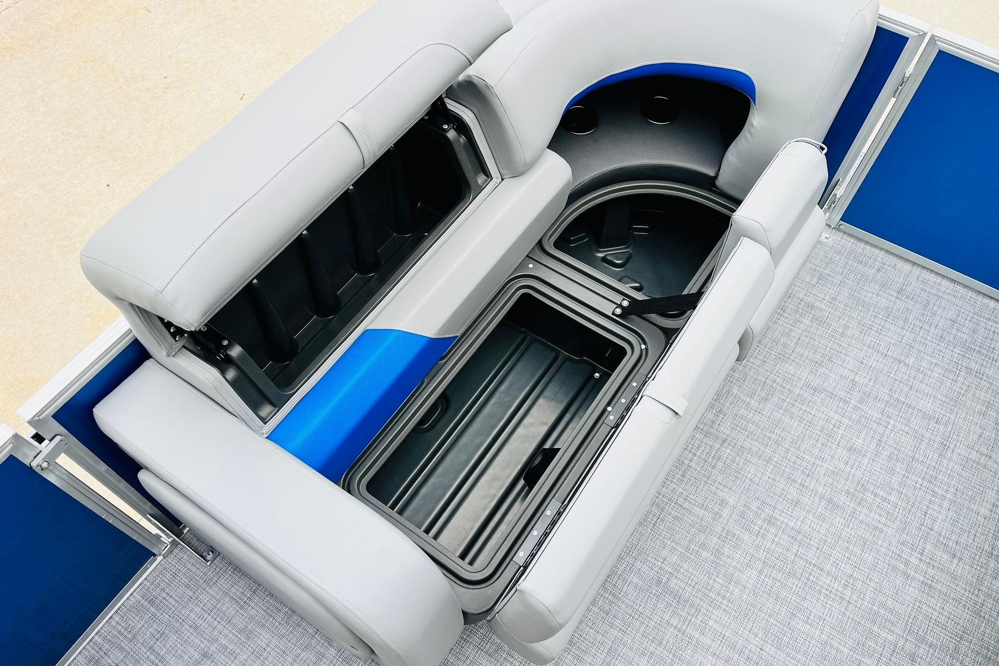 2026 Sun Tracker Party Barge 22 RF DLX seating with storage compartments open.
