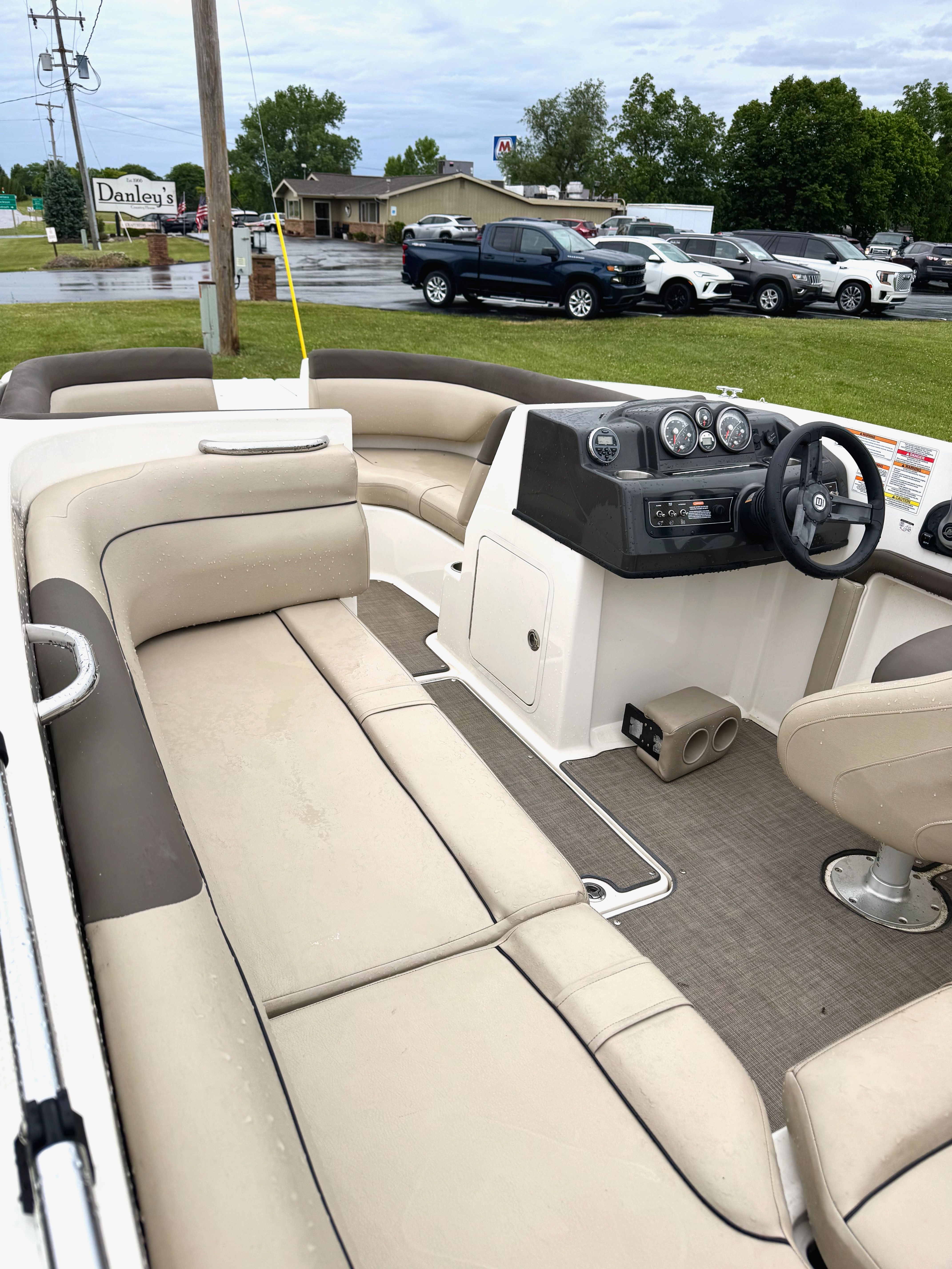 Interior view of a 2017 Bayliner Element E18 with beige seating and a helm console.