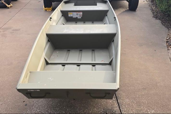 2026 Tracker Grizzly 14 Jon boat on pavement, showcasing interior seating and design.