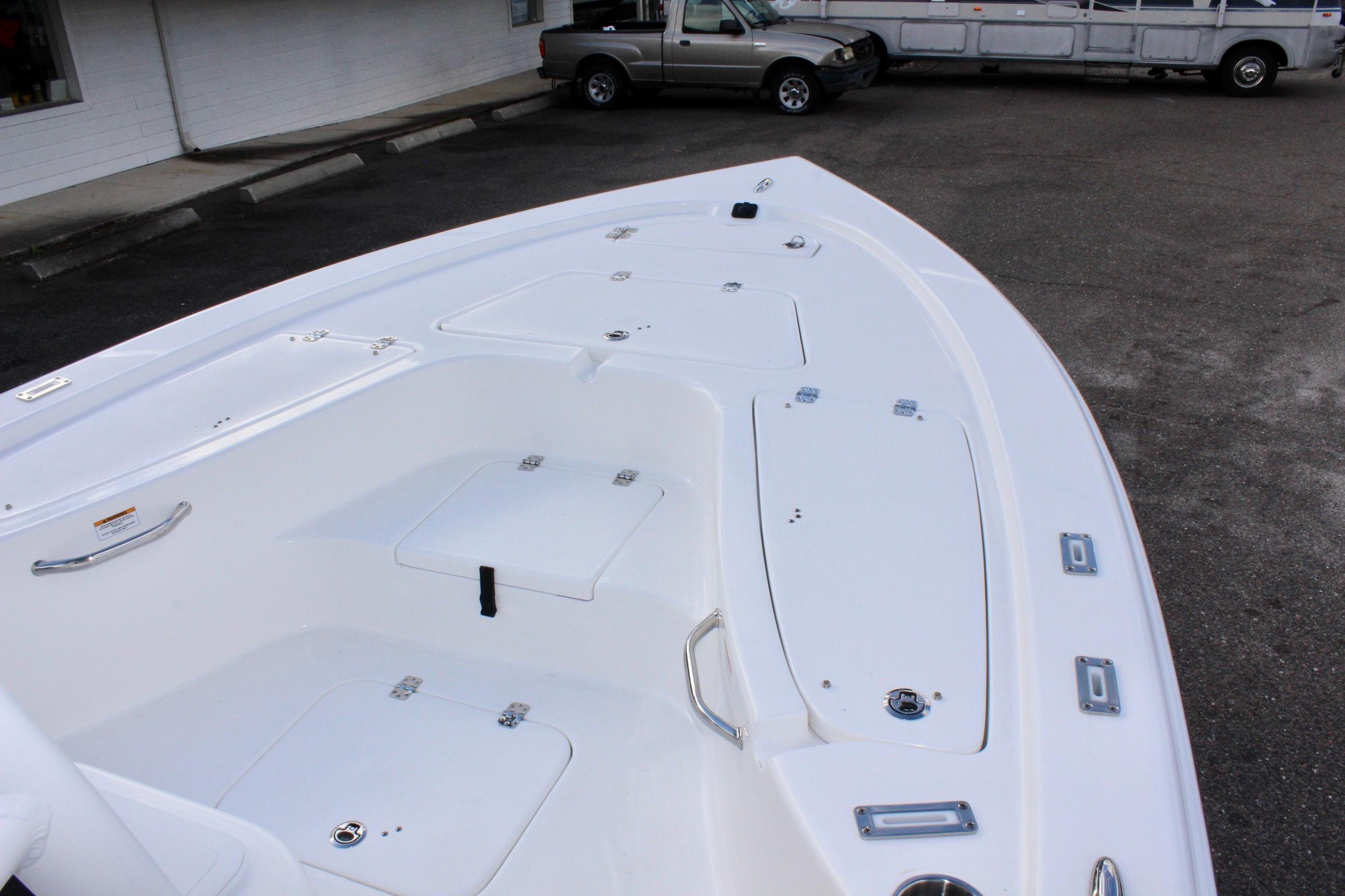 2025 Sea Pro 230 Bay boat deck with storage compartments, parked in a lot.