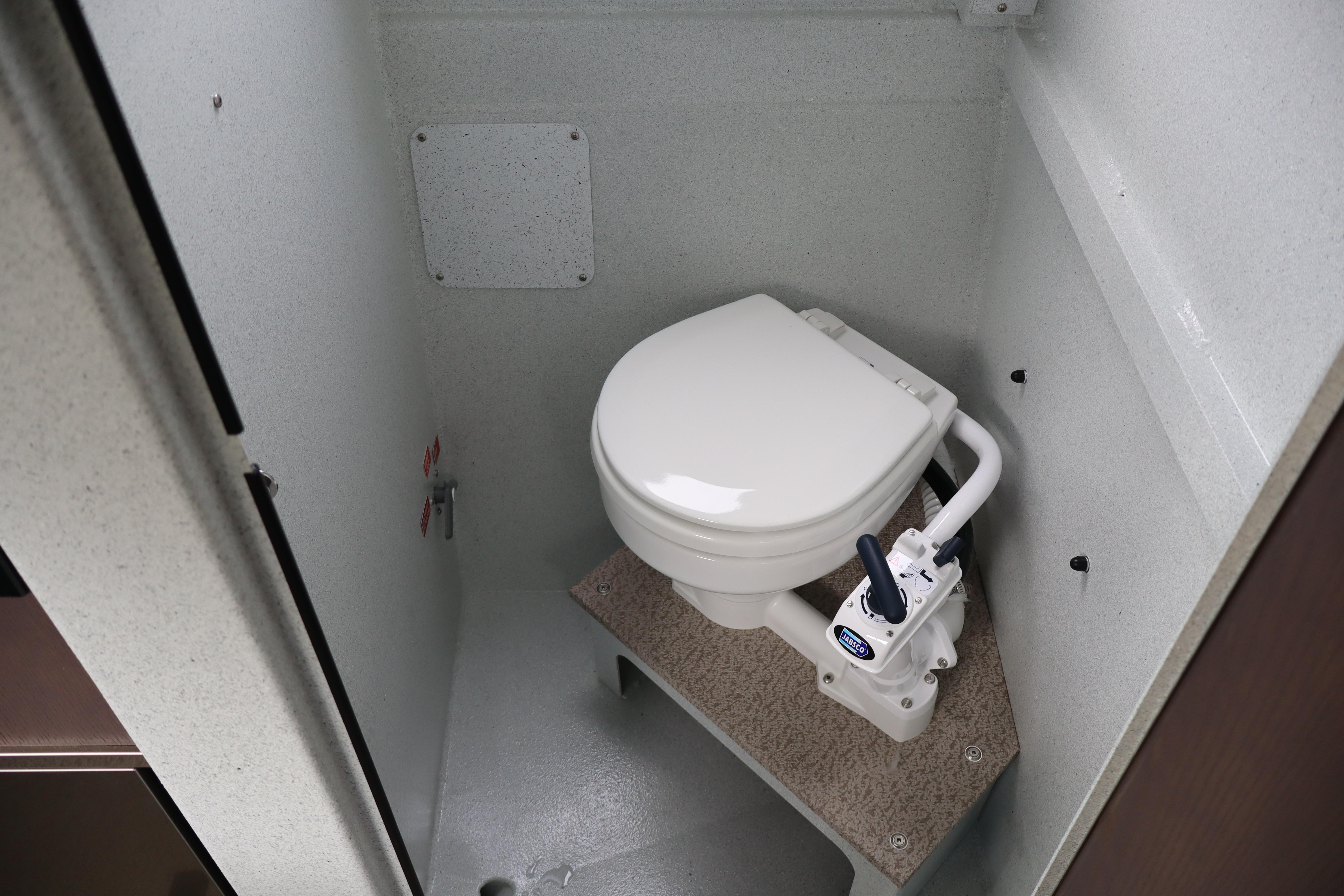 Compact marine toilet in KingFisher 3025 XRS, 2026 model, featuring manual flush system.