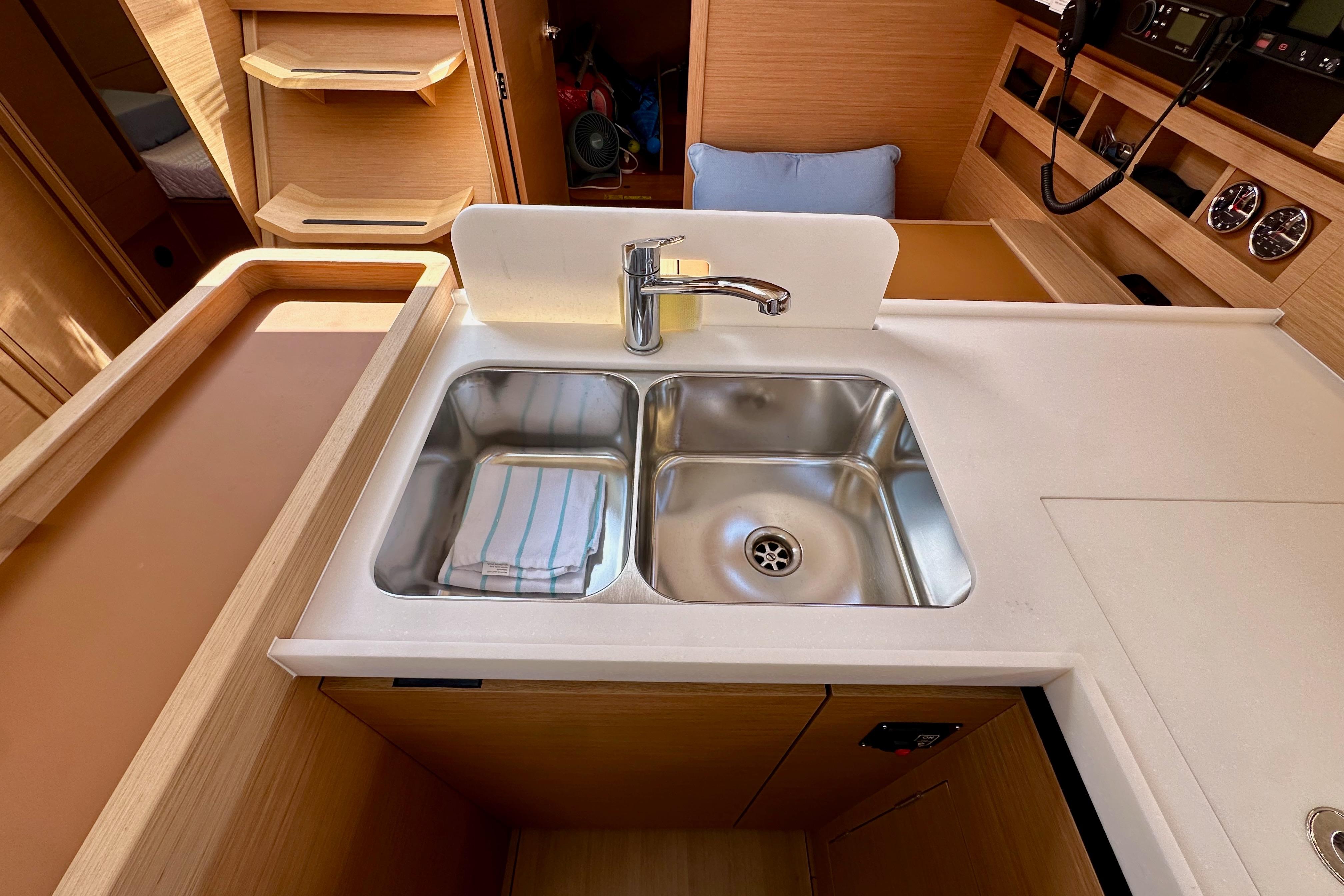 2024 Jeanneau Sun Odyssey 410 yacht kitchen with dual sink and modern wood cabinetry.