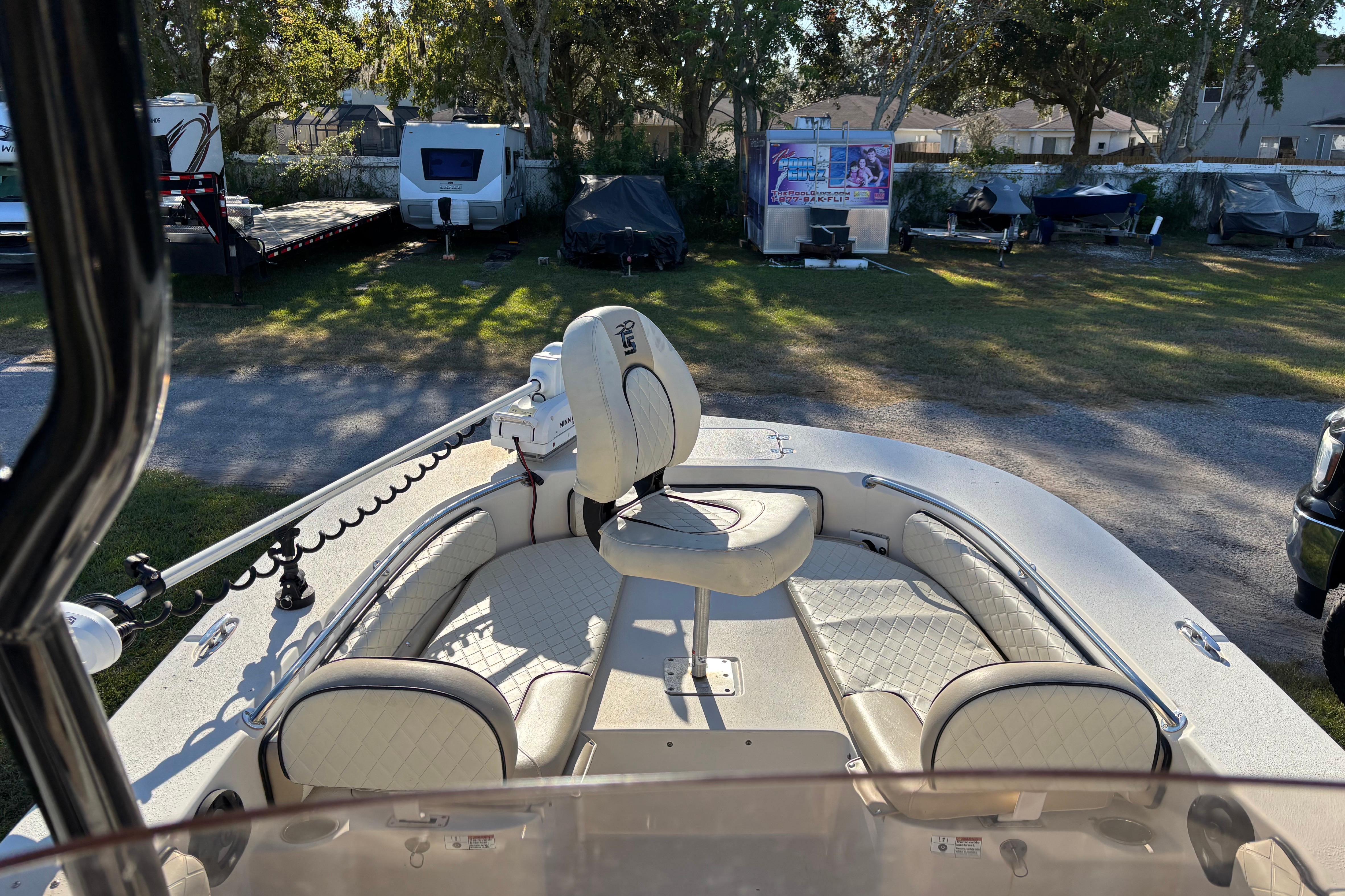 2021 Carolina Skiff 26 Ultra Elite boat with cushioned seating and trolling motor.