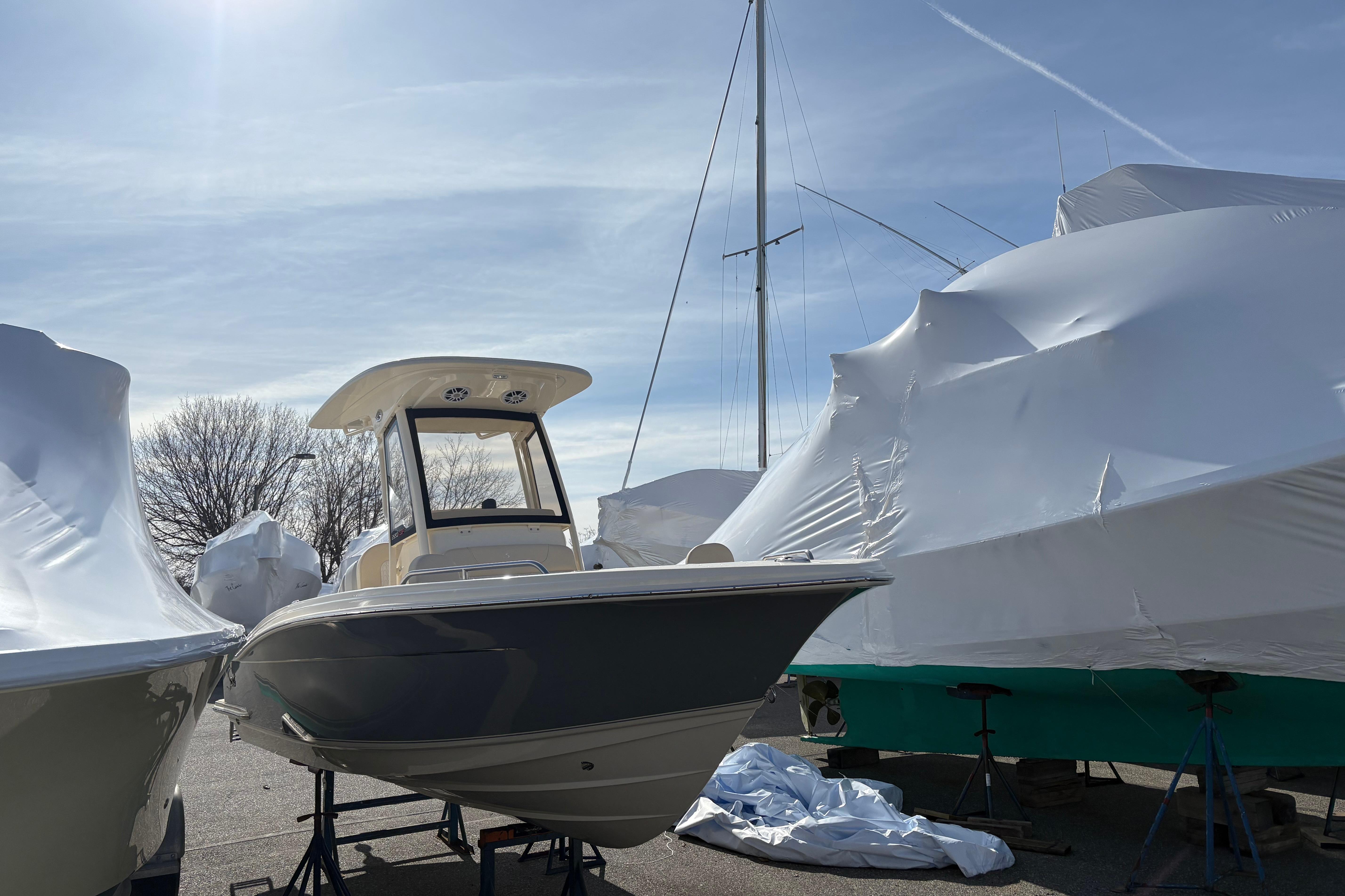 2026 Scout 220 XSF boat on display, surrounded by covered vessels under a clear sky.
