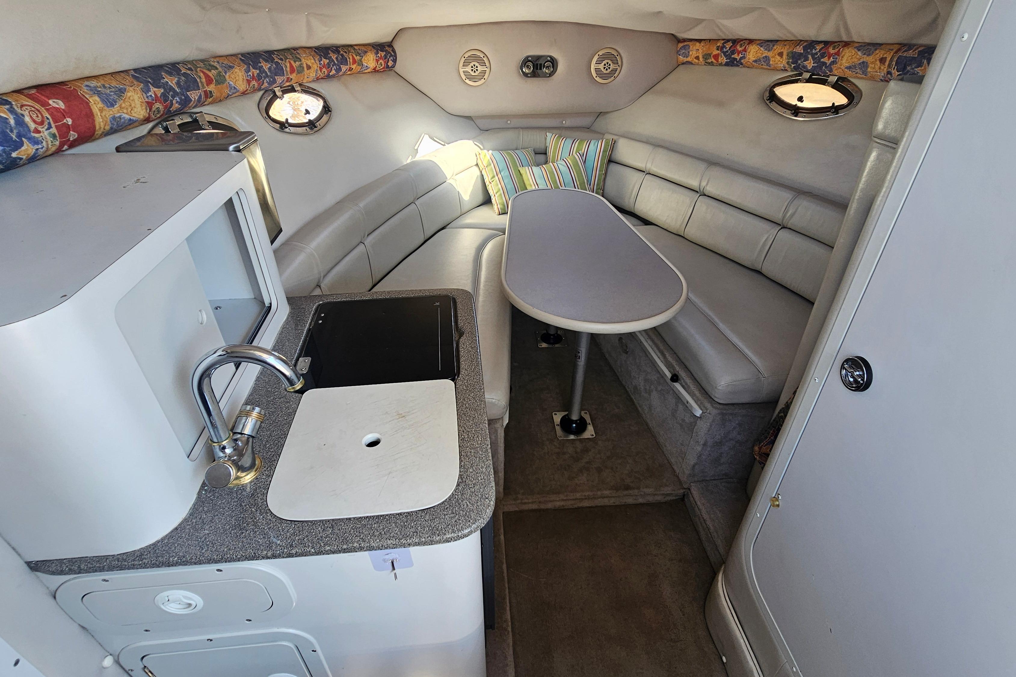Interior of 2000 Crownline 242 CR boat with kitchenette and seating area.