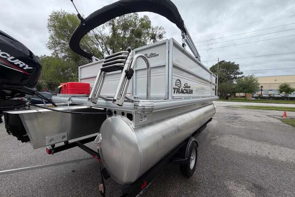 2026 Sun Tracker Party Barge 16 DLX pontoon boat on trailer, parked outdoors.