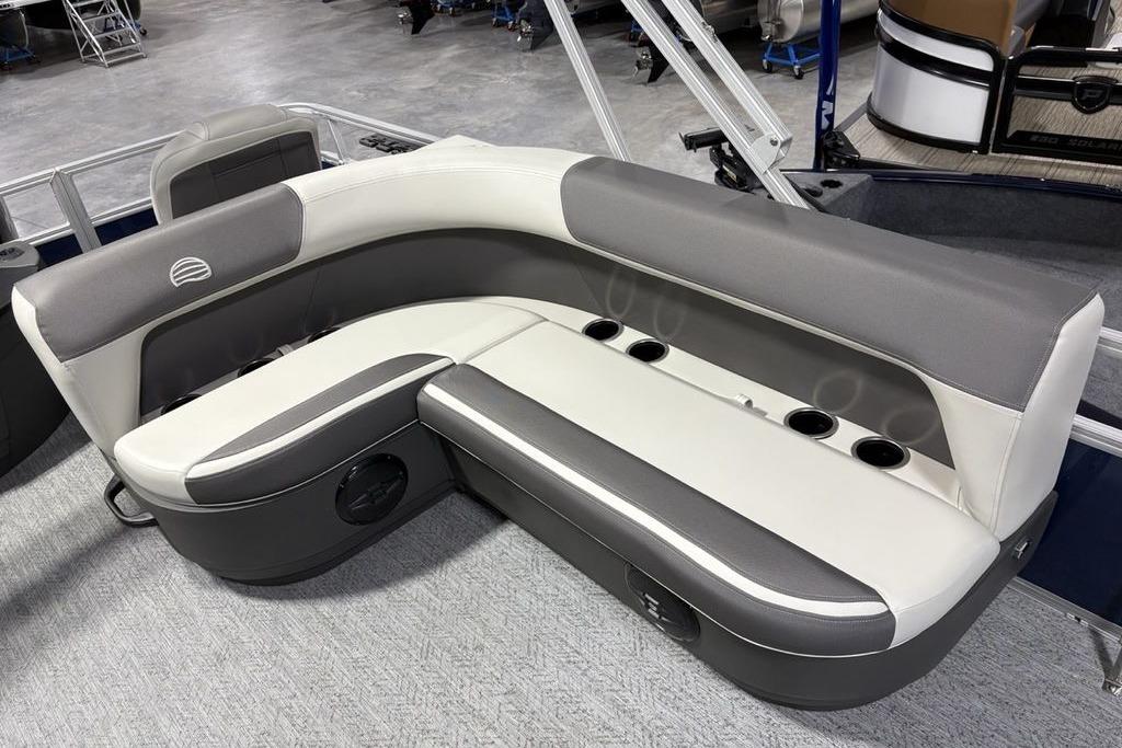 2026 Sun Tracker Bass Buggy 18 DLX pontoon boat seating with cup holders and gray upholstery.