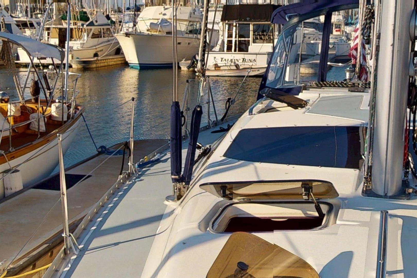 1997 Hunter Legend 40.5 sailboat docked in a marina, surrounded by other boats.