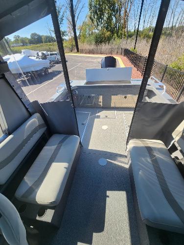 2025 Spartan 200 Astoria boat interior with seating and helm, parked outdoors.