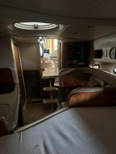 Interior of 2005 Four Winns 298 Vista boat, featuring cozy seating and wooden accents.