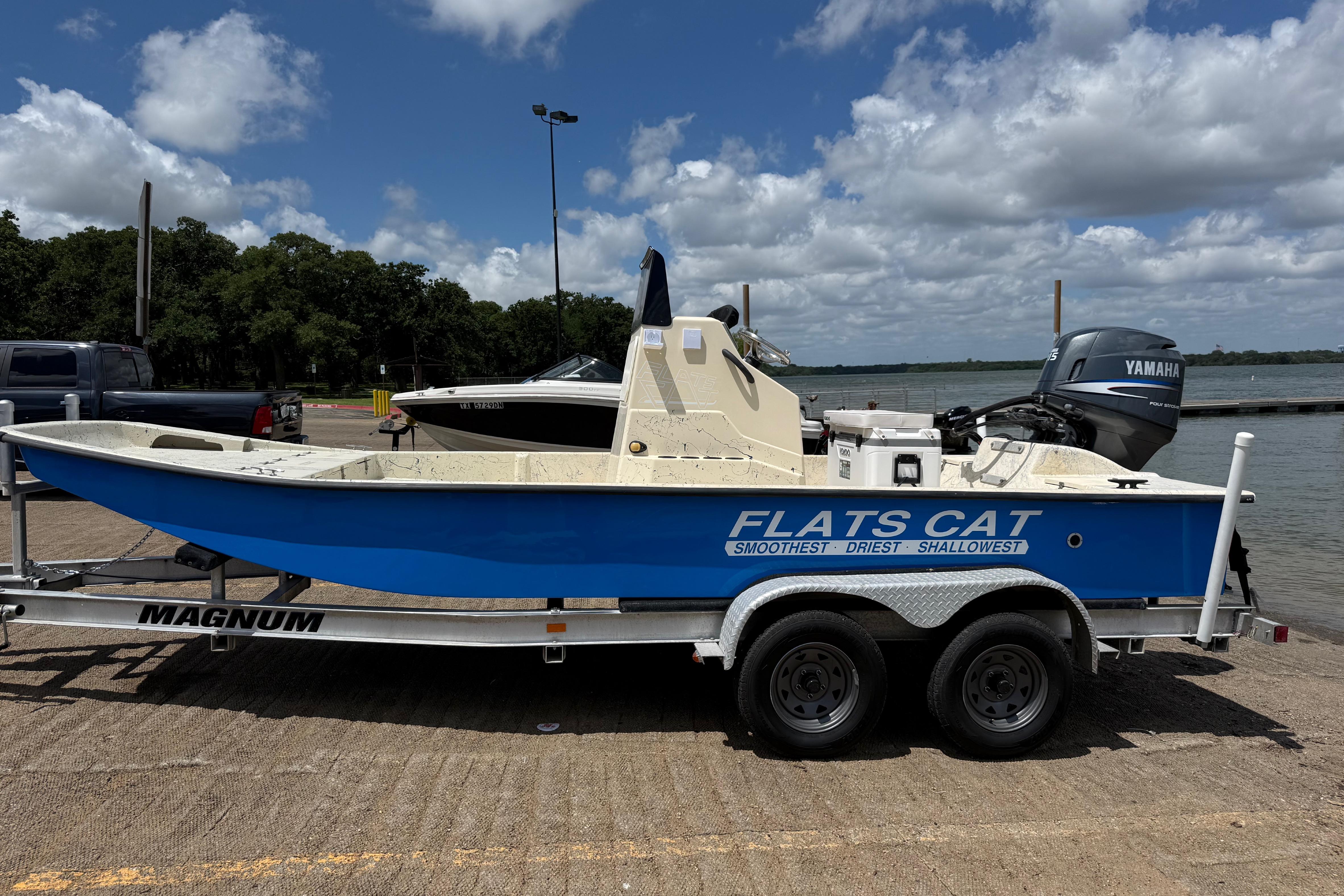 2007 Flats Cat 19 boat on trailer by lake, featuring Yamaha outboard motor.