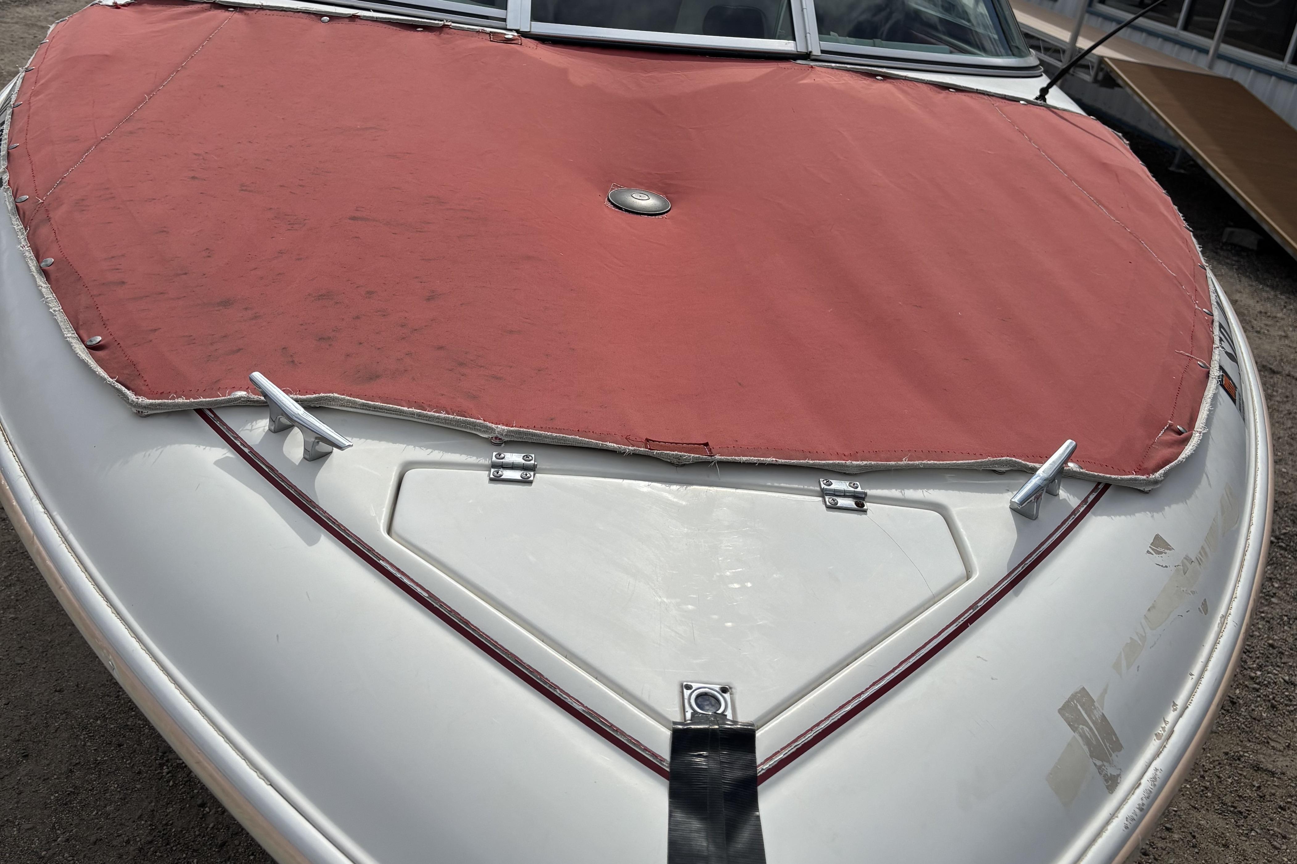 1993 Larson SEi 200 Cuddy I/O boat with red cover, front view.