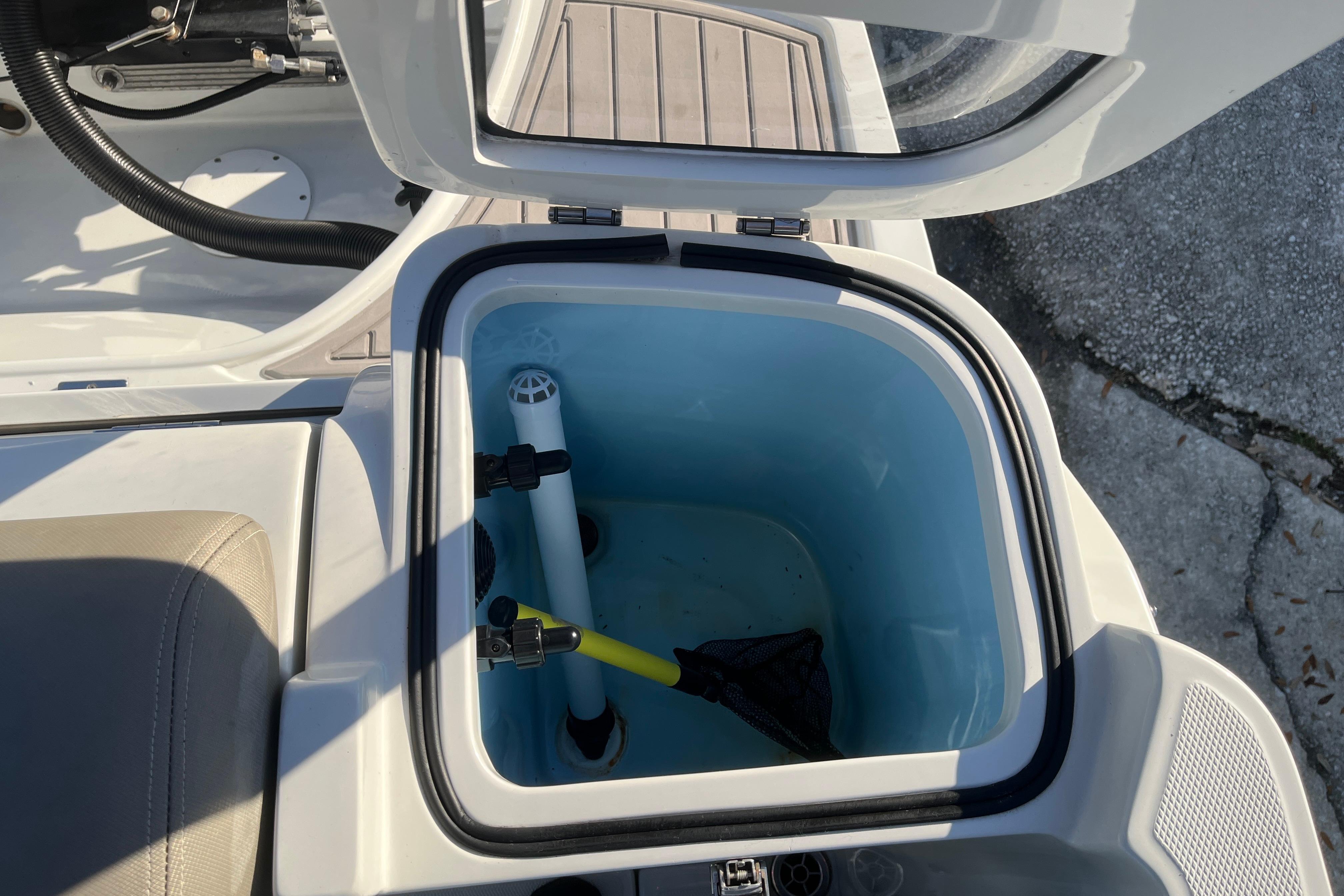 Open storage compartment on 2022 Finseeker 280 DC boat, showing interior details.