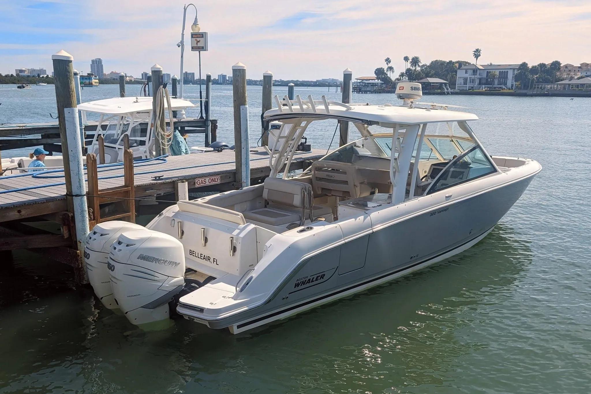 2017 Boston Whaler 320 Vantage docked, featuring twin Mercury engines, in a serene marina setting.