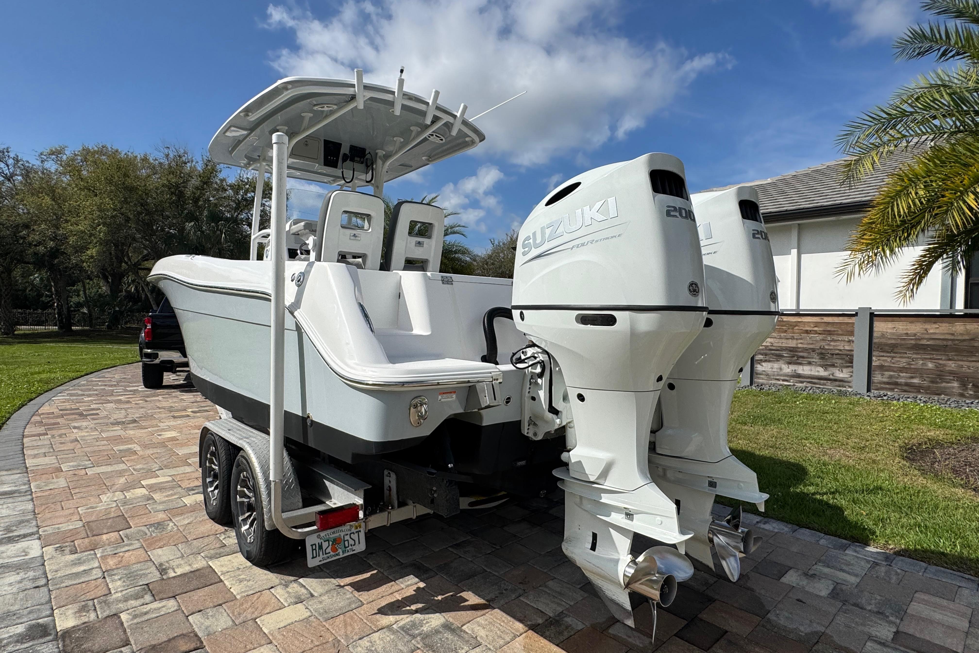 2022 Aquasport 2500 Center Console boat with dual Suzuki engines on a trailer.